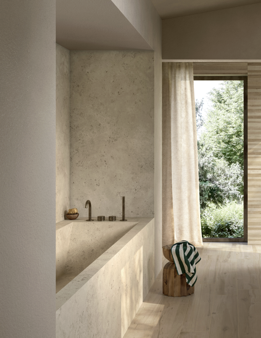 Interieur van een minimalistich badhuis met een natuurstenen wastafel, een grote ramen met uitzicht op groen landschap, en een houten stoel met een gestreept handdoek.