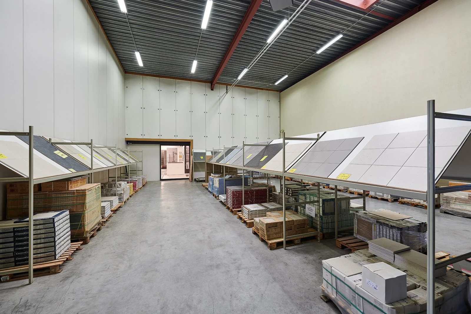 Woonwinkel met tegels en vloerplaten op display in magazijn.