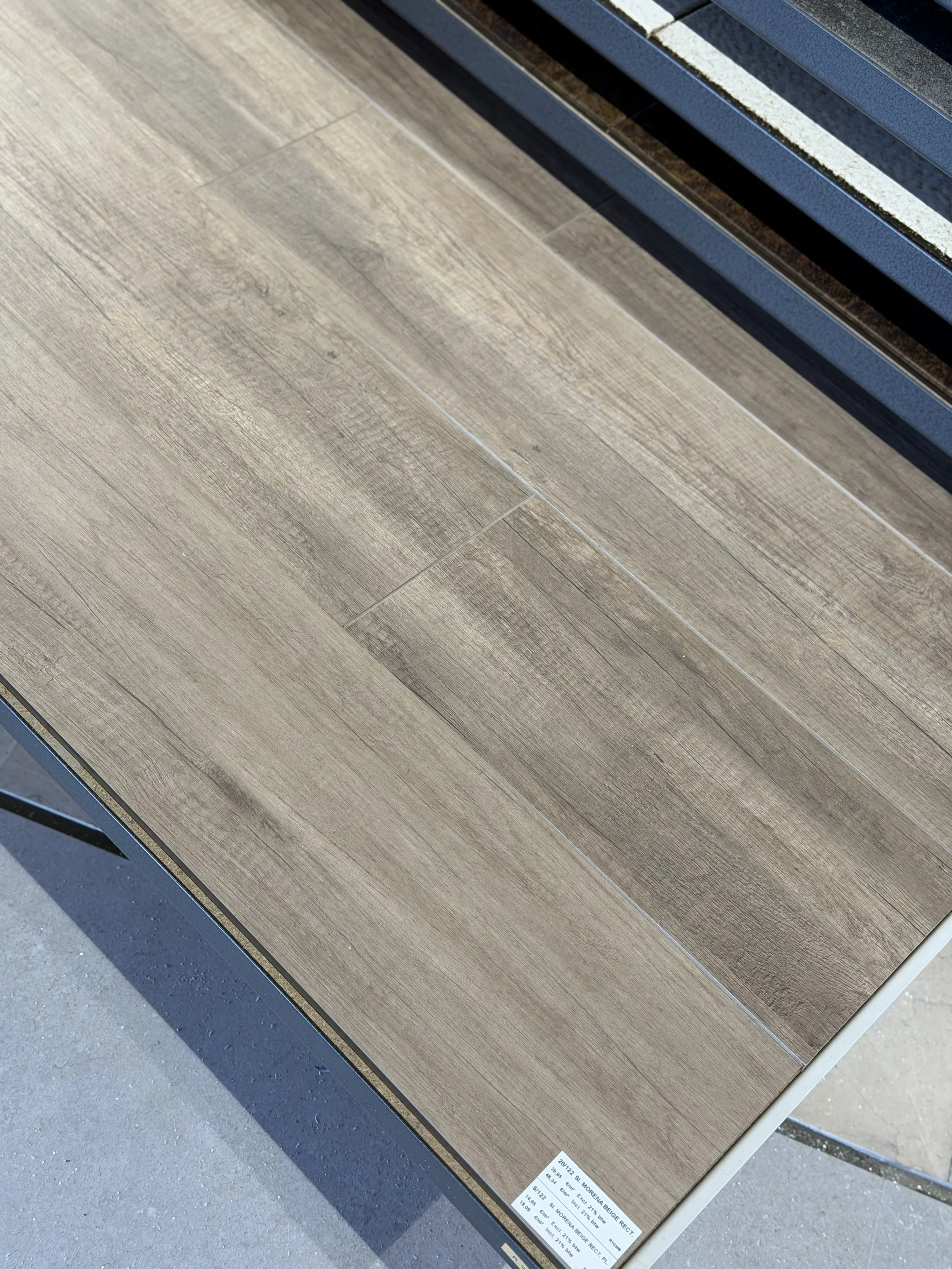 Twee houtlook tegels in licht eikenkleur, gelegd op een vlakke ondergrond.