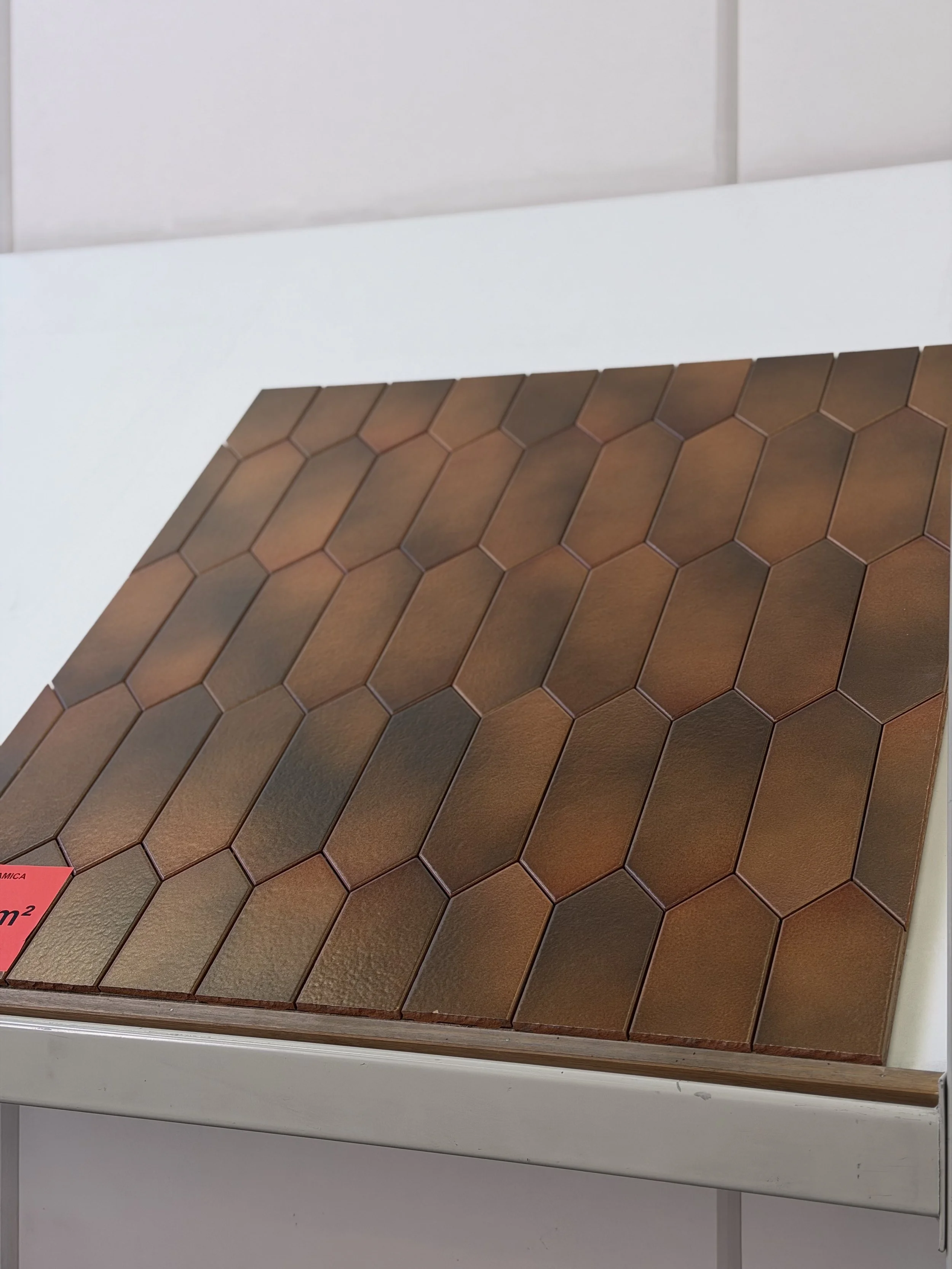 Nieuwe bakstenen in diverse aardse tinten dan geplaatst op een muur, allemaal met een hexagonale vorm.