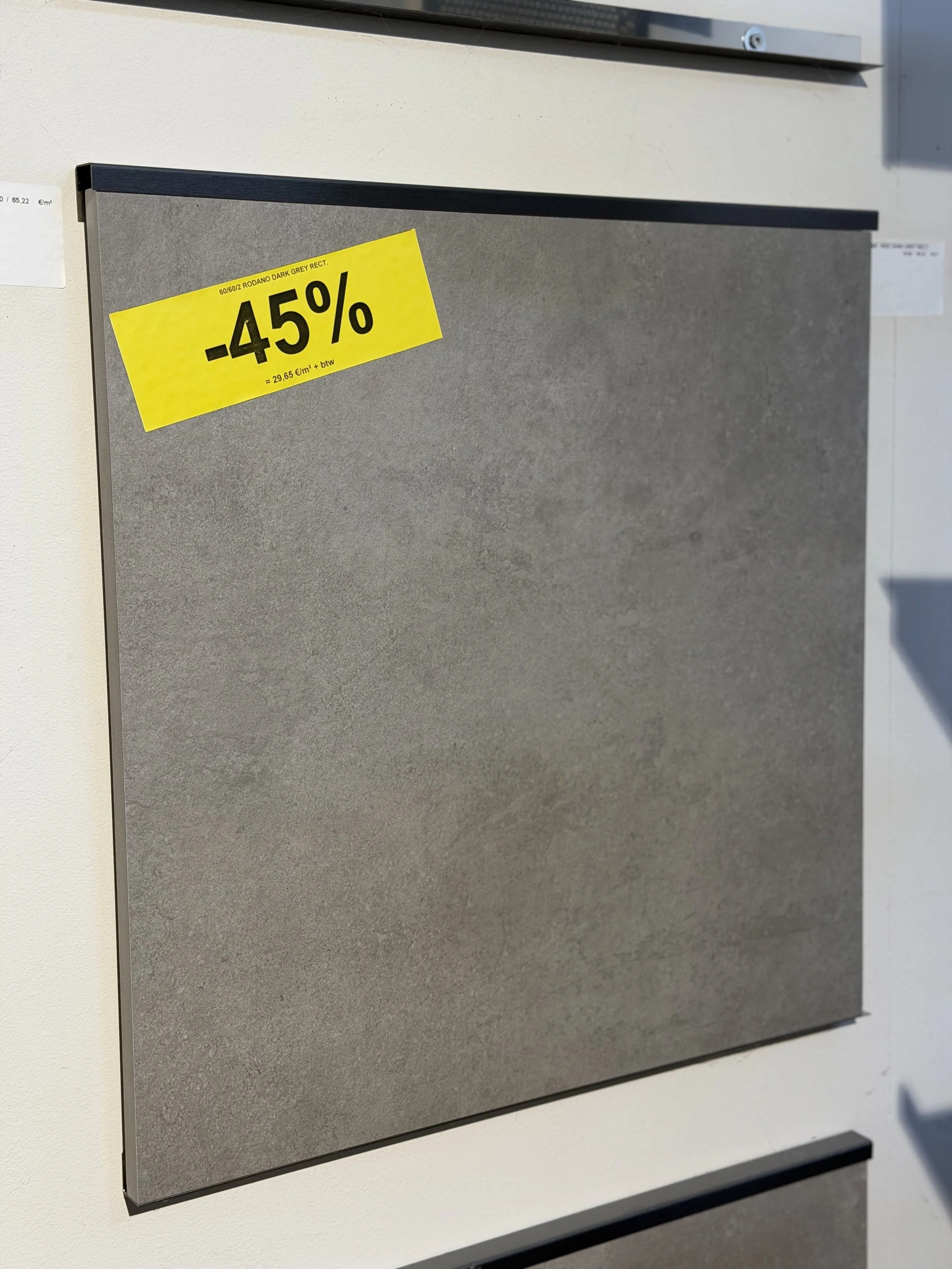 Een grijze, rechthoekige vloerplaat met een gele kortingsetiket dat 45% korting aangeeft.