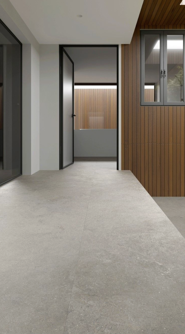 Een modern interieur met een glazen deur, houten wandpanelen en een raam met uitzicht op een balkon of patio.