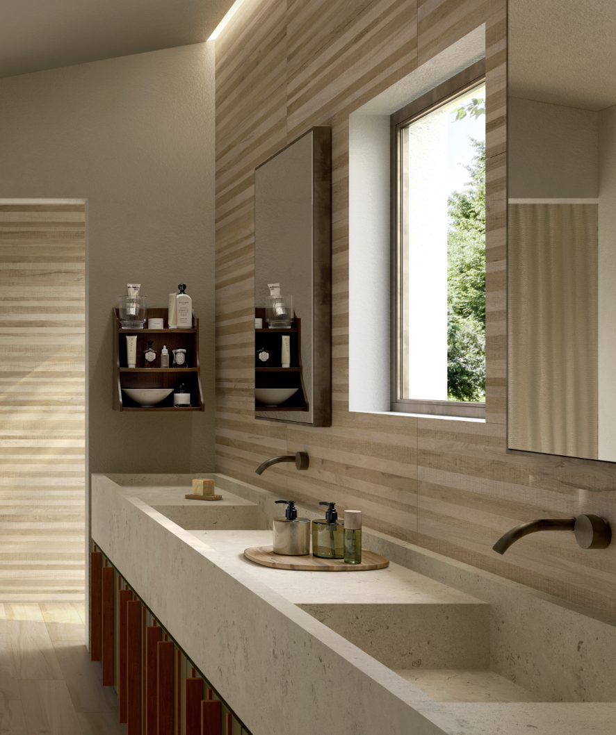 Moderne badkamer met dubbele wastafel, grote spiegel, open raam met groen uitzicht, houten en beige tegels, en verzorgingsproducten op draagplateau.
