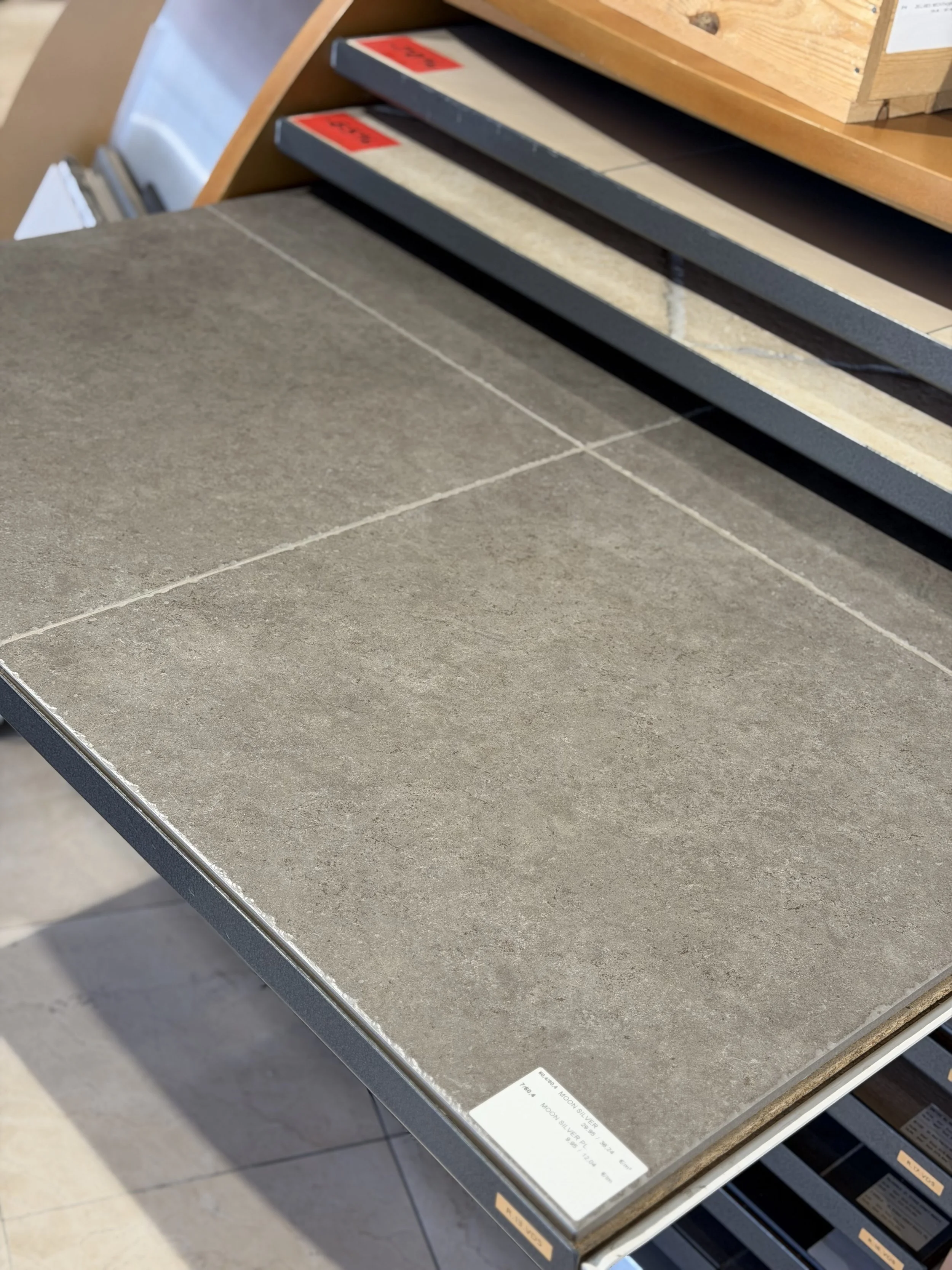 Tegeltableau met verschillende kleuren en texturen, gelegen in een winkel of showroom.