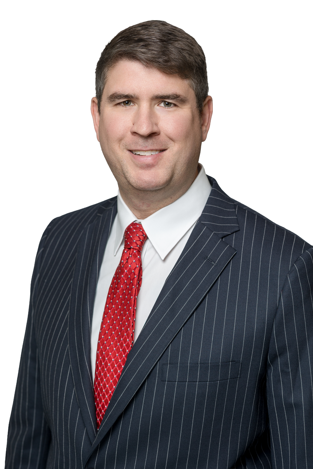 Professional headshot of a smiling man in a dark pinstripe suit, white shirt, and red patterned tie