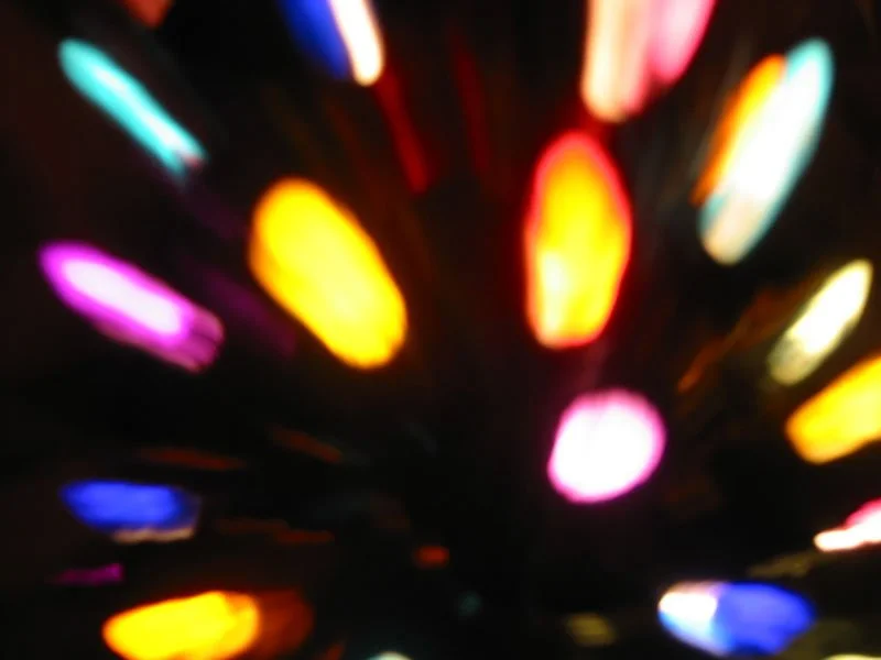 Blurred bokeh lights in many colors on a black background.