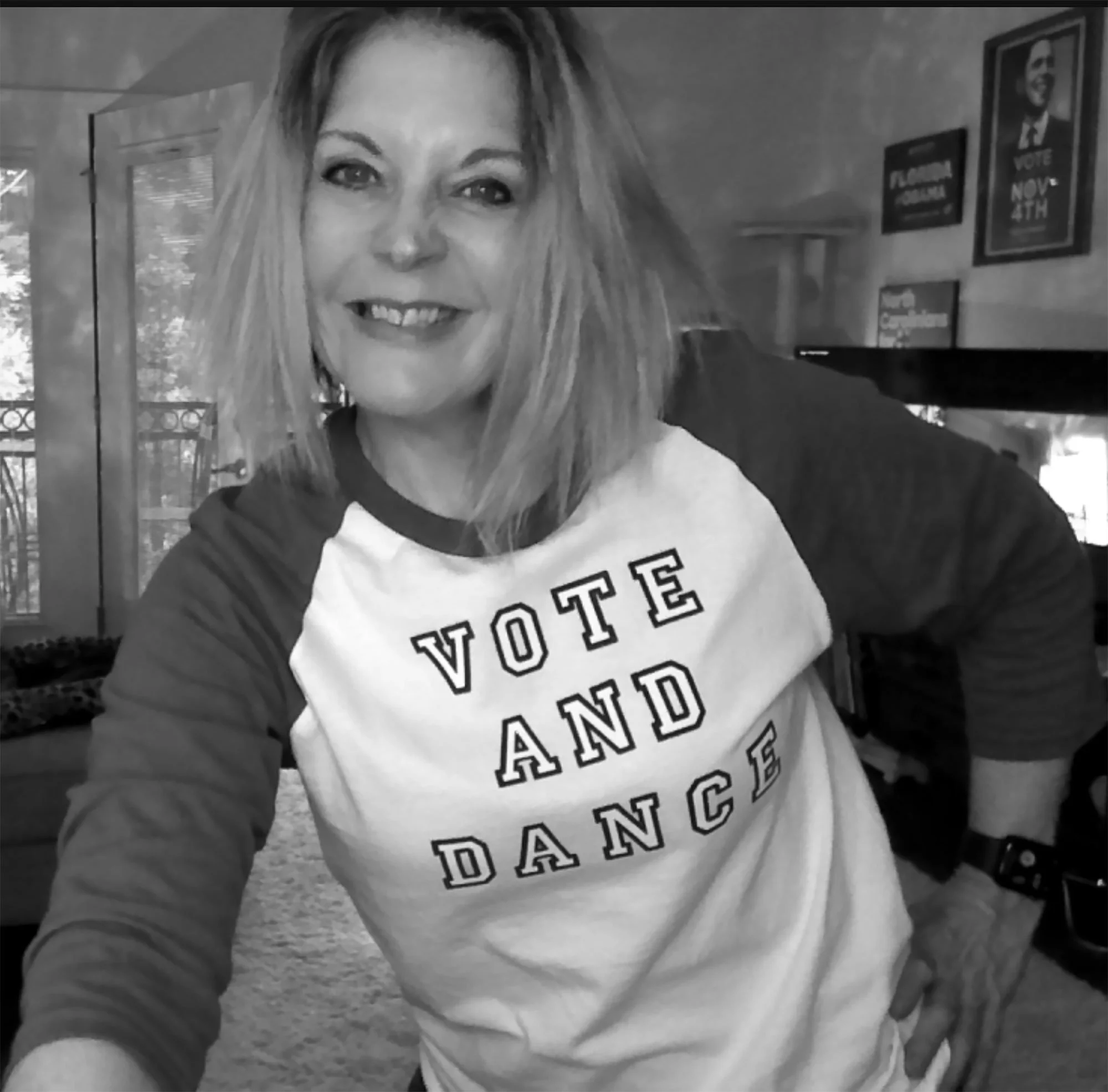 Claudette Silver smiling and wearing a shirt that says "vote and dance"