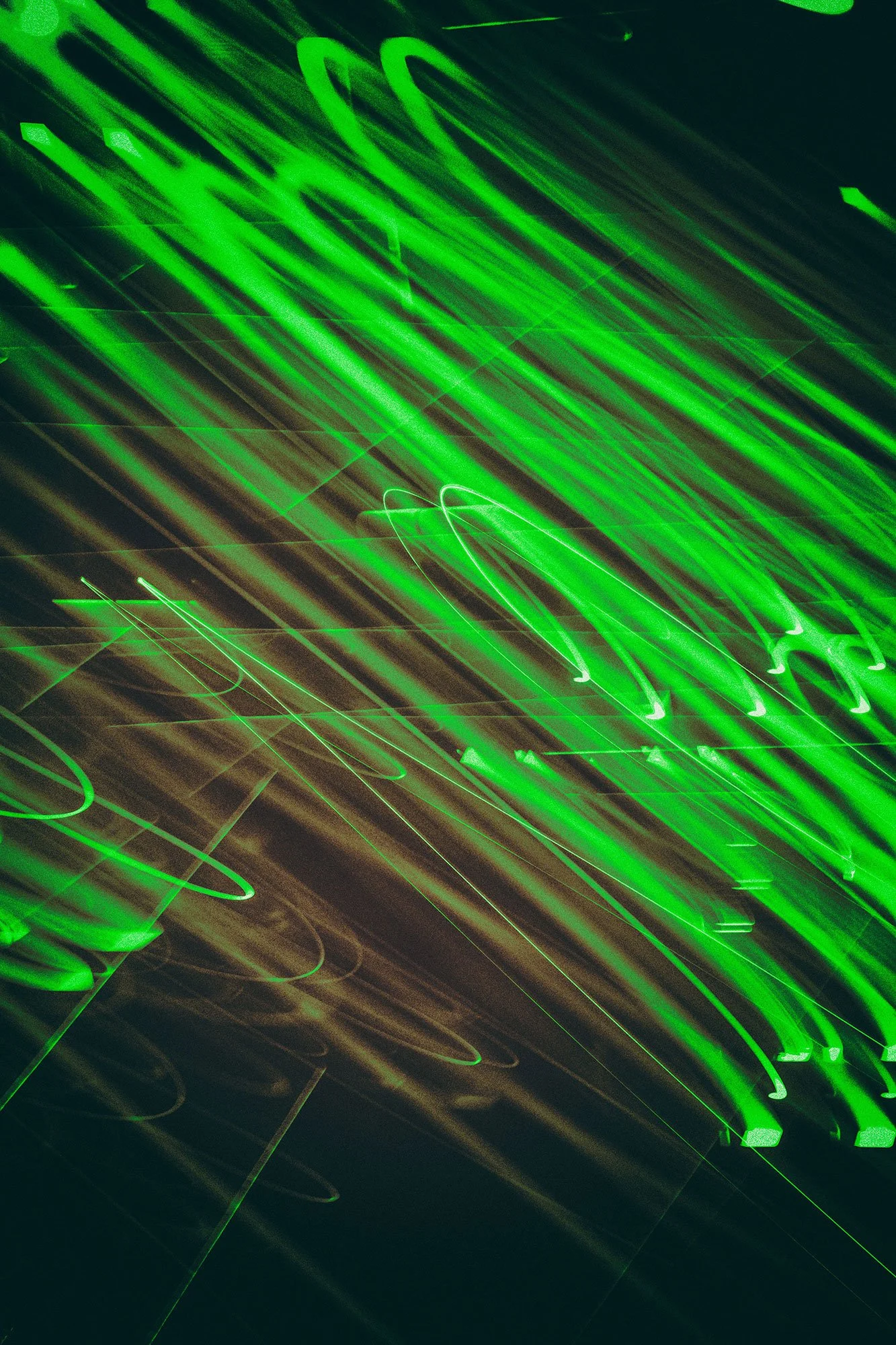 Blurry neon green lights that look like they're in motion in darkness