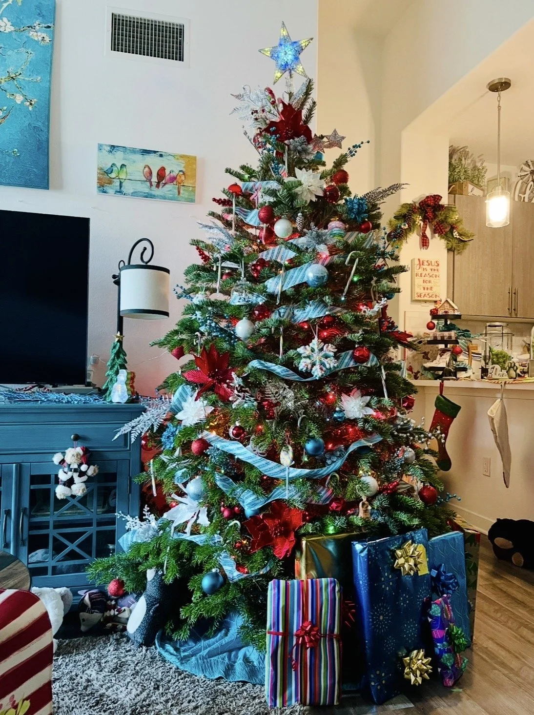 Jolly Holiday Classic- A beautifully balanced, vibrant green holiday tree layered with rich crimsons, traditional ornaments, and a glowing star to anchor your home in classic warmth. 