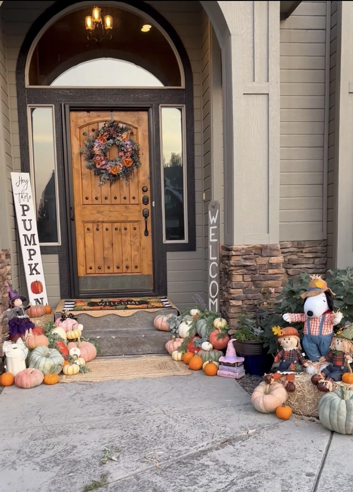 The Grand Entrance Masterpiece — A breathtaking showcase of full-scale entryway styling on Cherry Tree Lane. This luxury harvest presentation features massive, meticulously balanced columns of rare heirloom pumpkins, festive scarecrow accents, and cu