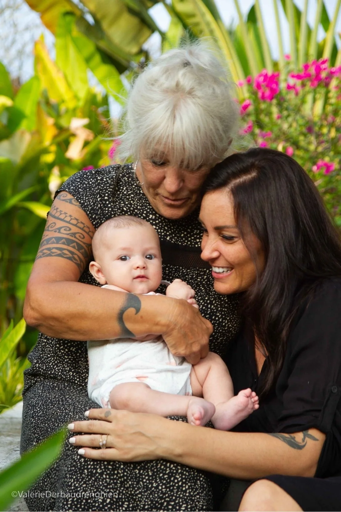 Grandmother, mother and baby share a tender moment in a garden, a three-generation family portrait