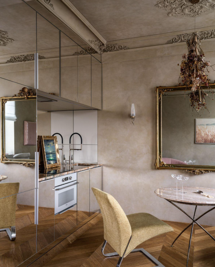 Reflective modern kitchen contrasting mirrored cabinetry with ornate ceiling moldings, antique gilded mirrors, herringbone wood floors, and sculptural furnishings.