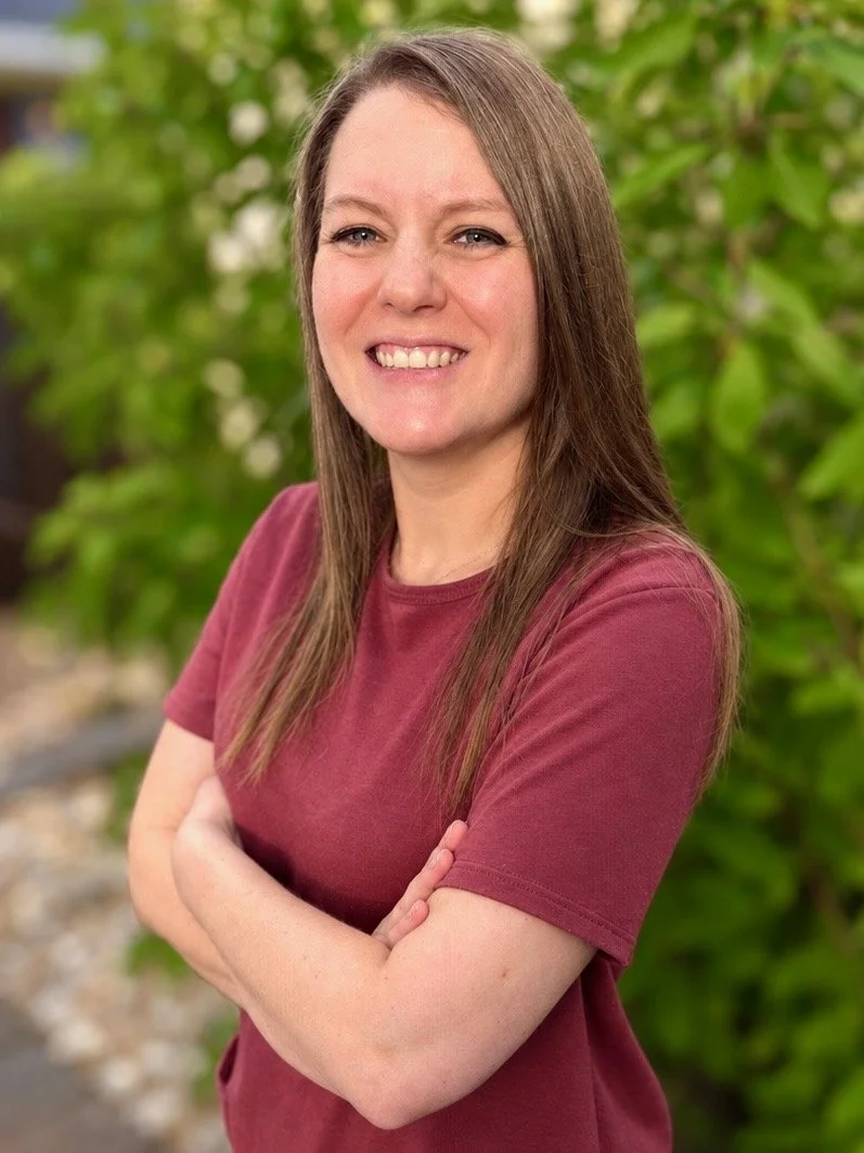 Shannon Hafterson, LPC in dark mauve dress with greenery background