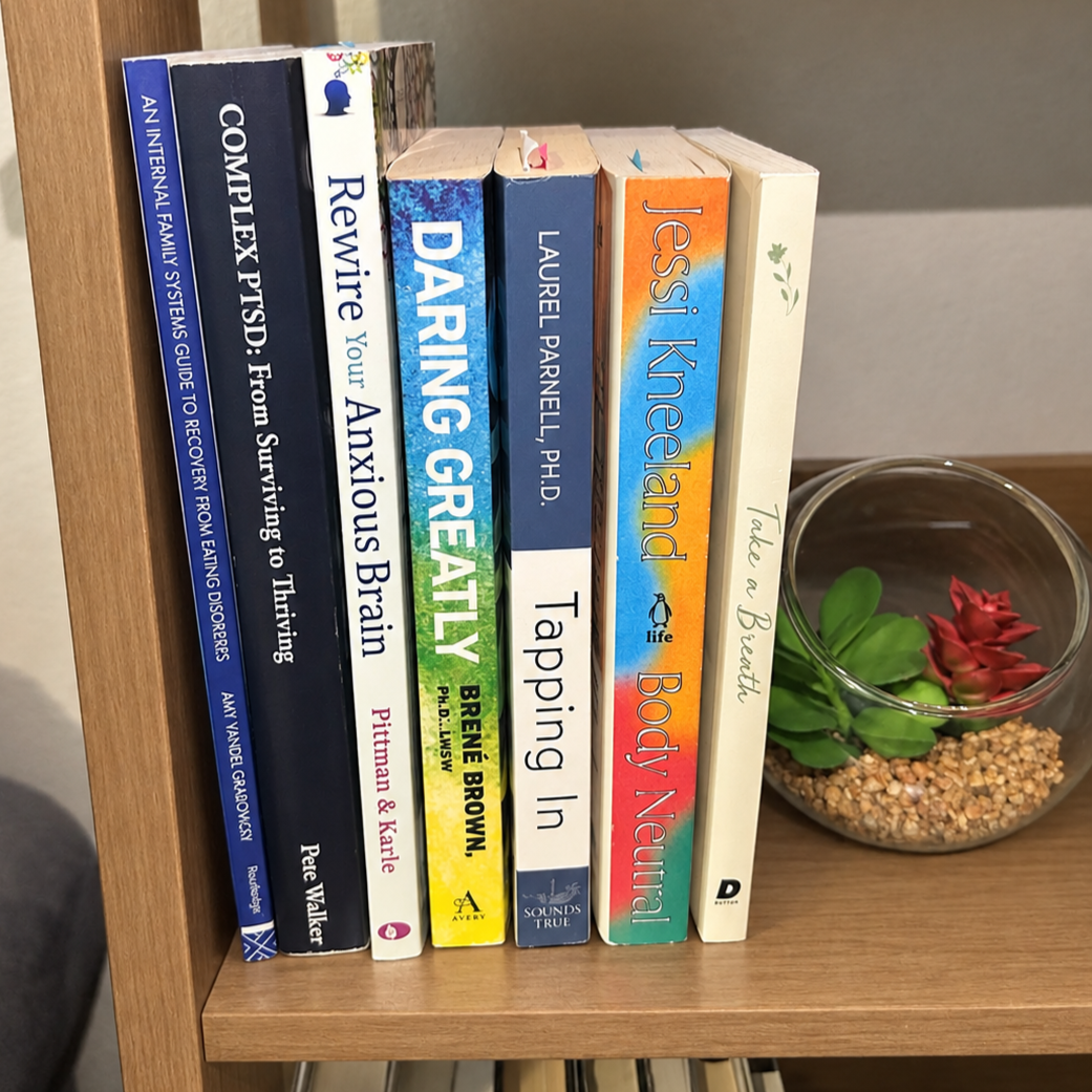Row of self-help and therapy books on a shelf