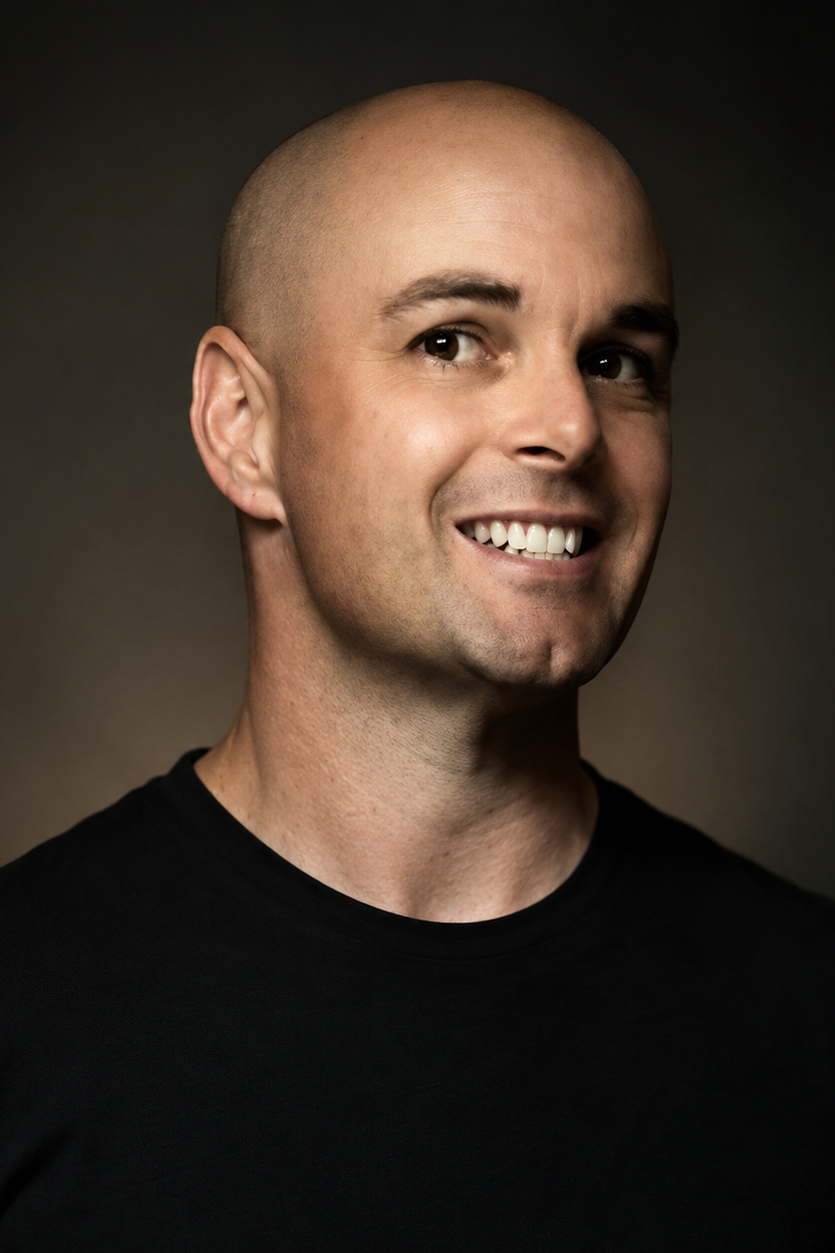 Portrait of the owner of North Eleven Entertainment wearing a black shirt against a dark background.