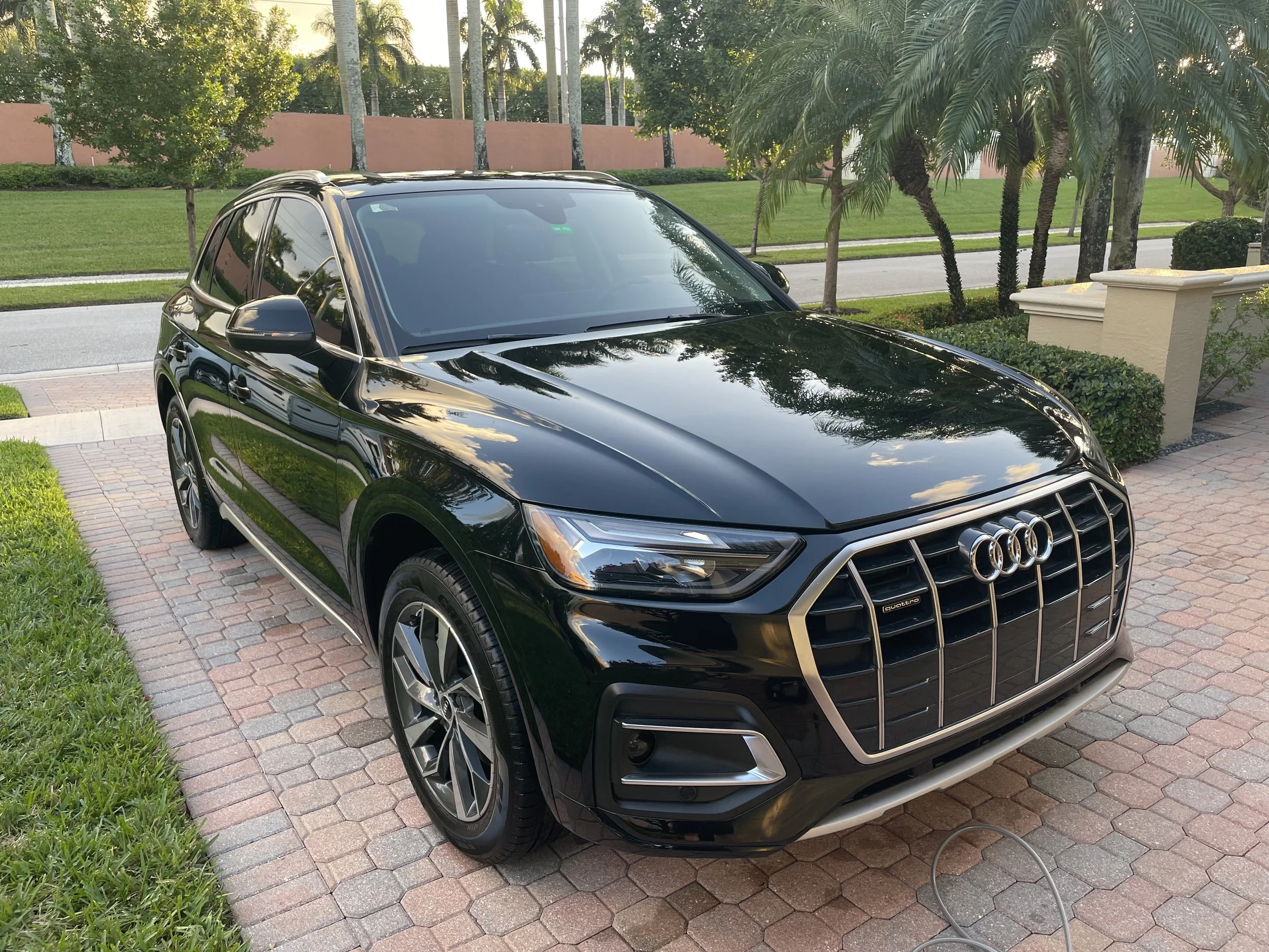 Deep gloss black Audi Q8 SUV exhibiting high-definition mirror reflection after a multi-step paint correction in Wellington, Florida.⁠