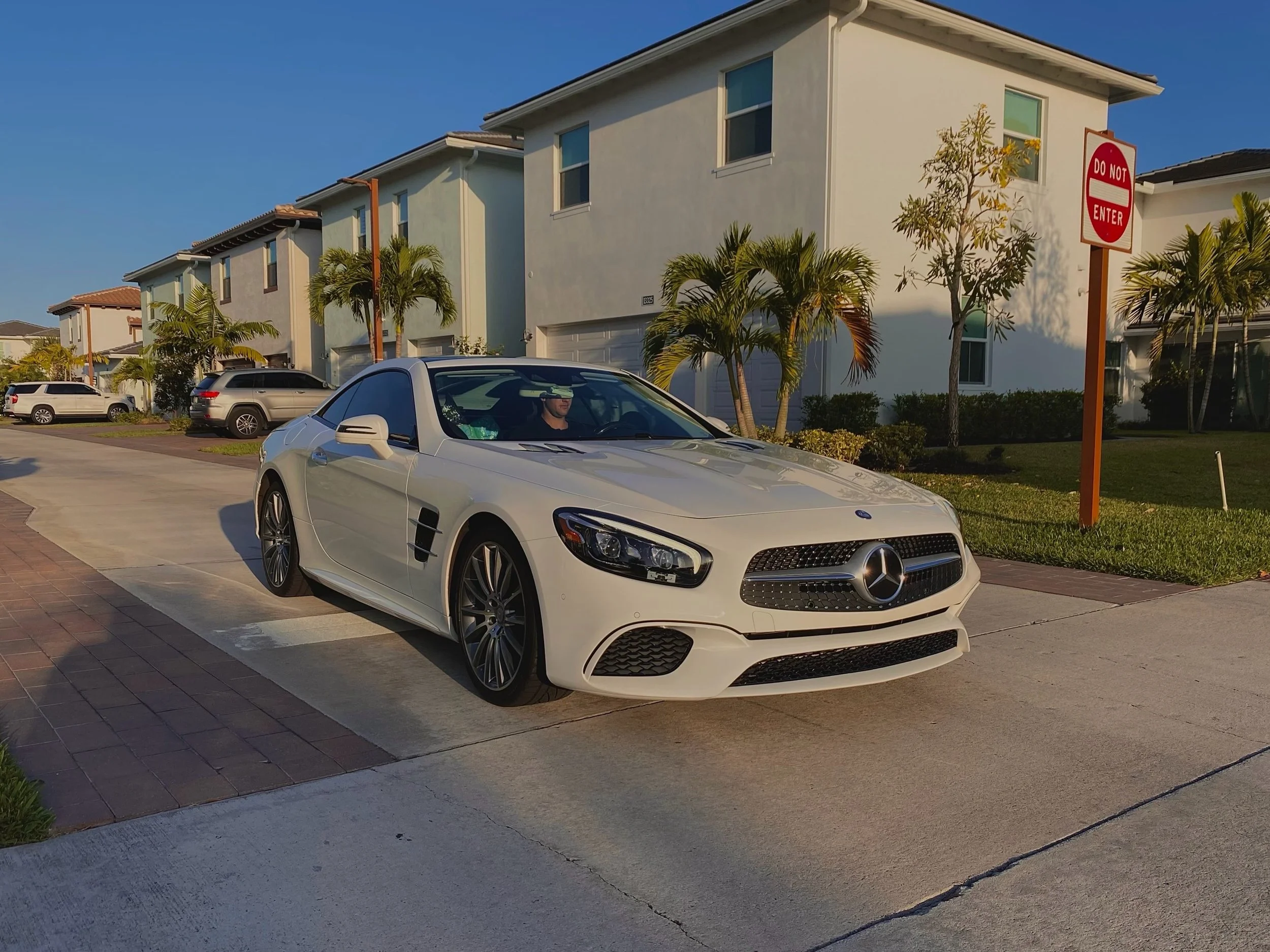 Sleek white Mercedes-Benz CLS-Class coupe parked outside, showcasing our premium ceramic coating surface reflection in Palm Beach Gardens⁠