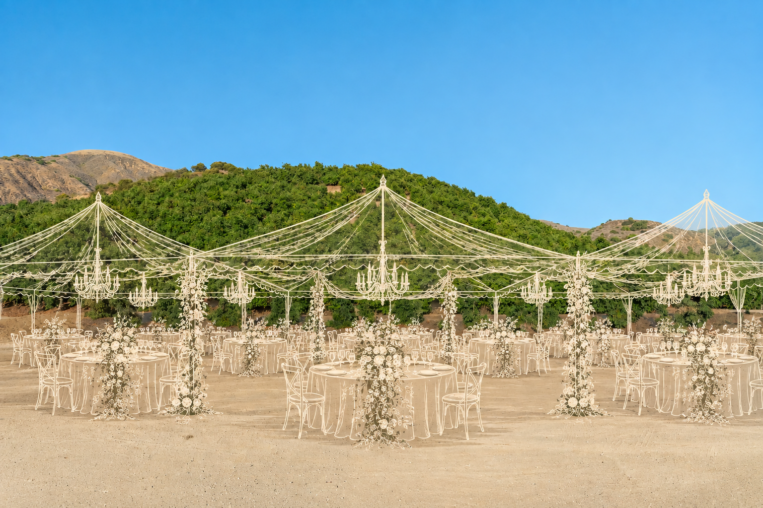 Outdoor wedding reception setup with decorated tables and chandeliers under a clear blue sky and green hills.