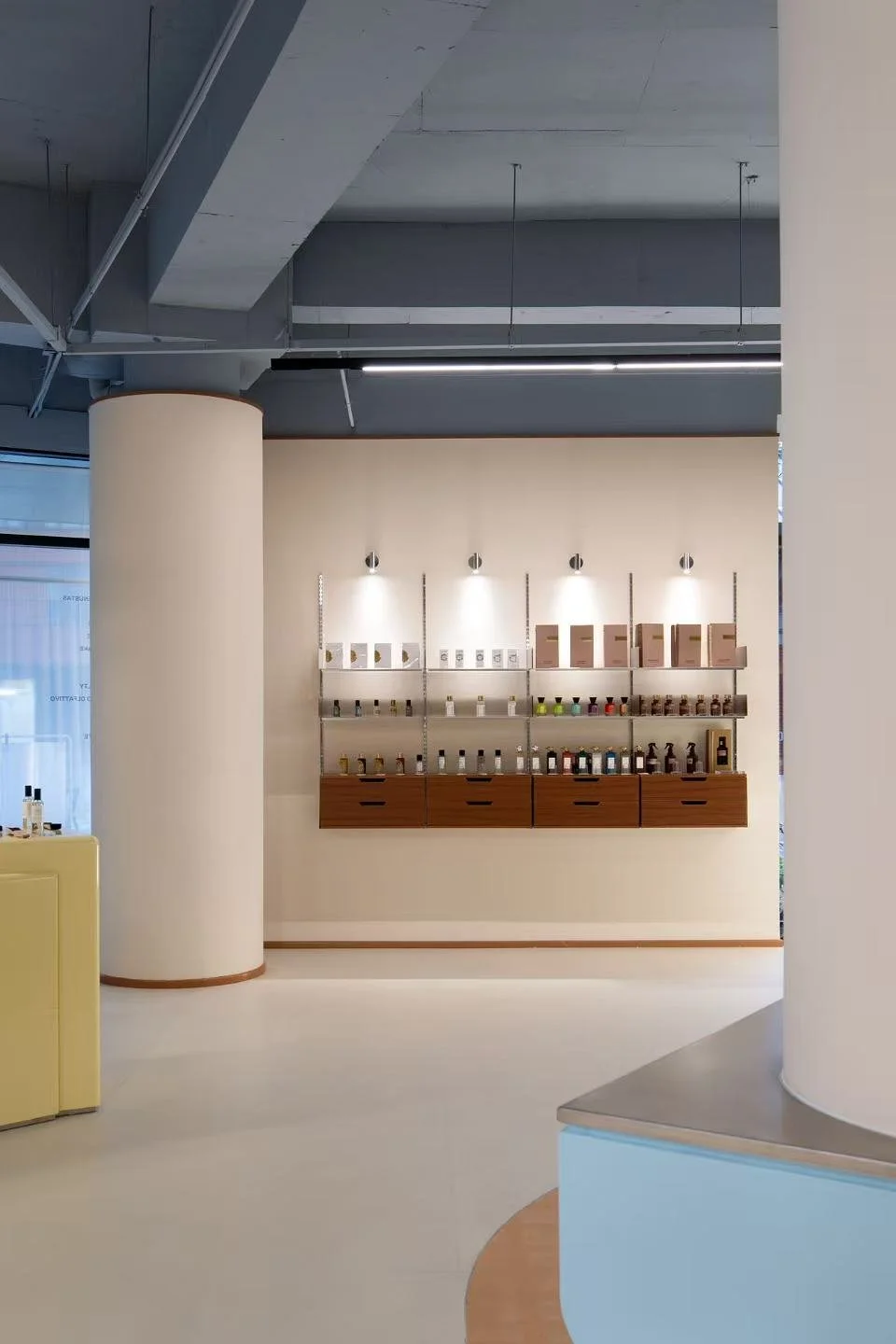 Display shelf with bottles and boxes in a minimalist store interior.