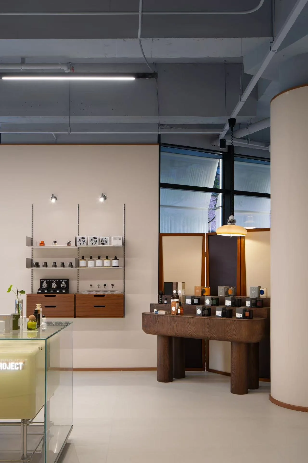 Interior of a modern store or boutique showcasing skincare and fragrance products on display shelves and tables with minimalist decor.