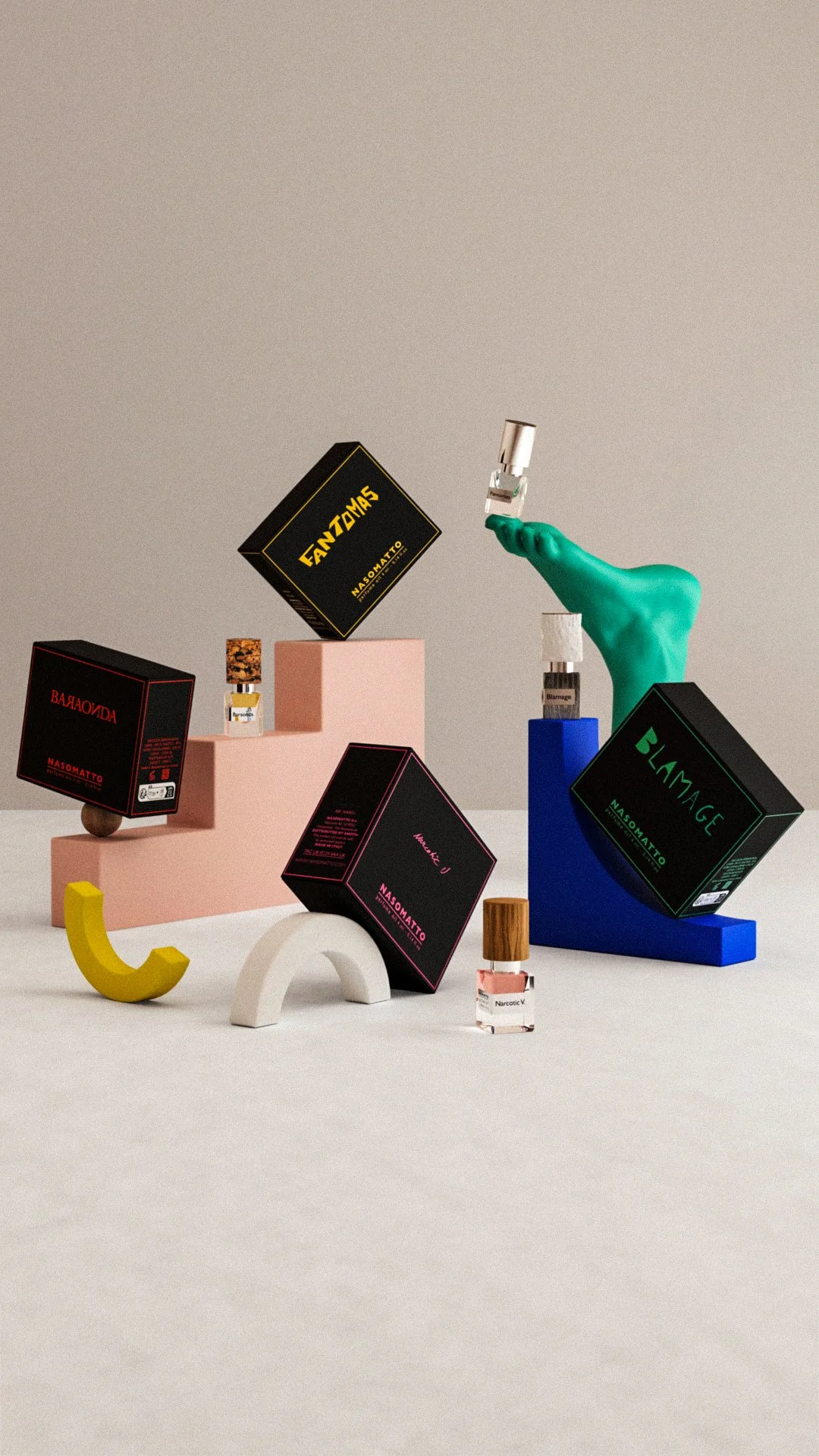 Display of various colorful perfume bottles and boxes on geometric stands and shapes with a plain background.