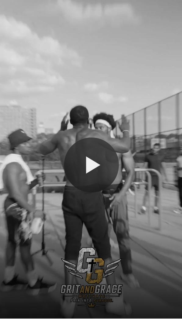 Two shirtless men talking, one with a headband, in an outdoor basketball court with a chain-link fence, other people in the background, in black and white.