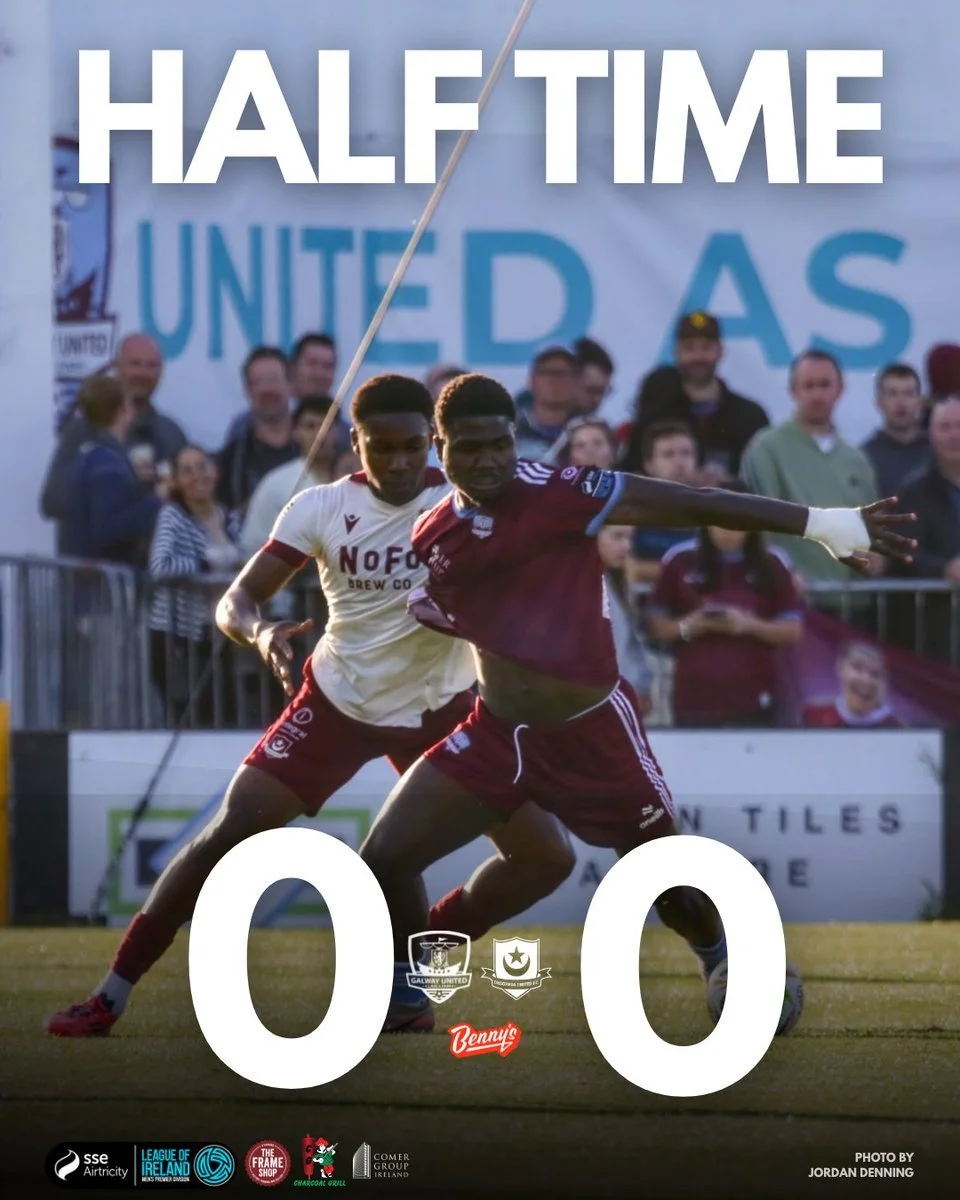 A soccer match in progress with players vying for the ball, spectators in the background, and a scoreboard showing a 0-0 tie. The image is overlaid with the text 'HALF TIME'.