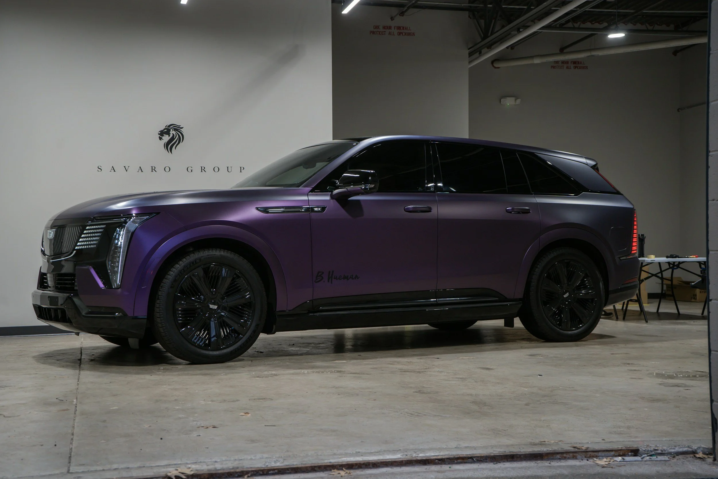 Purple gloss vinyl-wrapped SUV parked in a garage