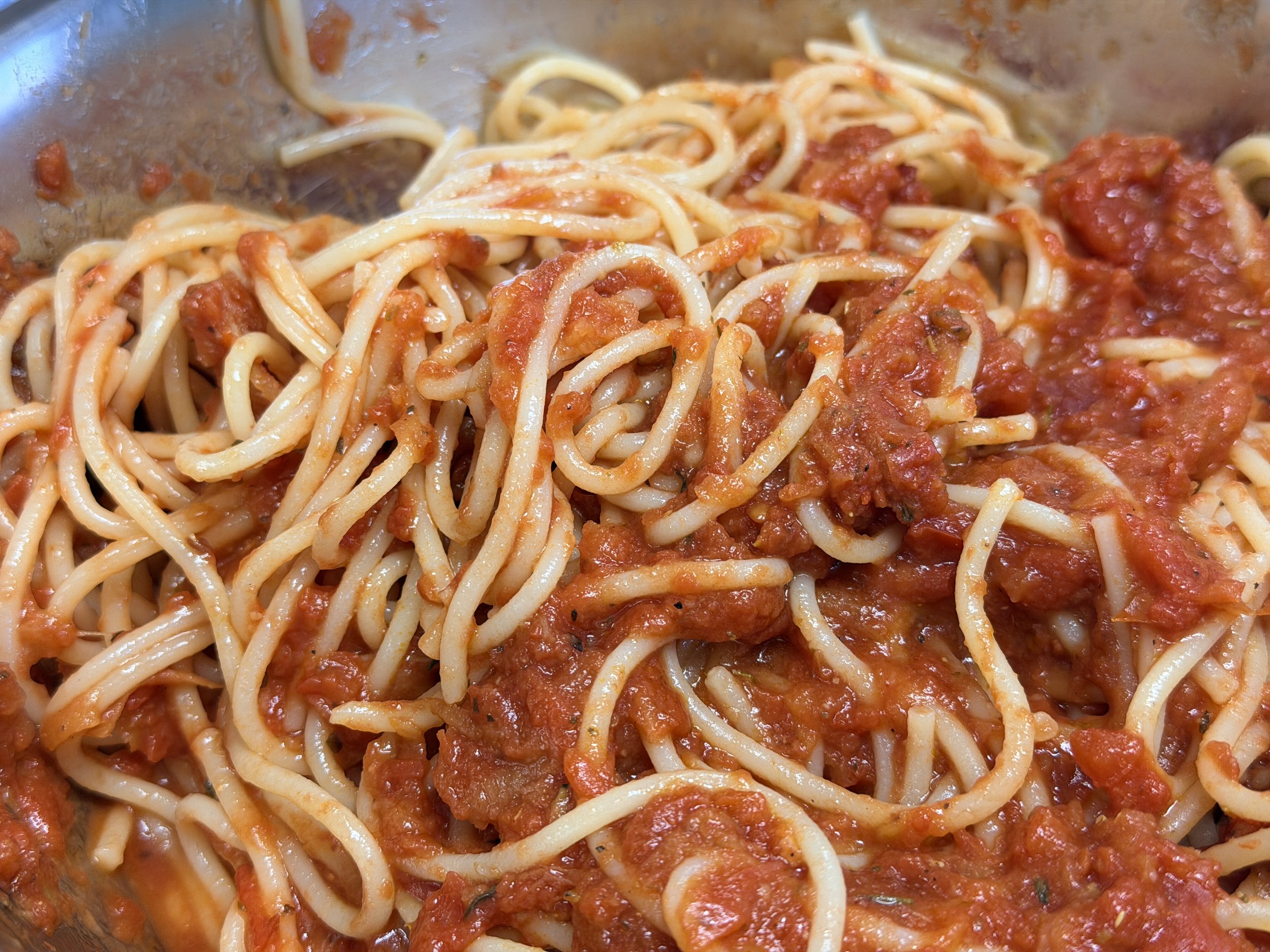 Spaghetti noodles served with a tomato-based sauce in a bowl.