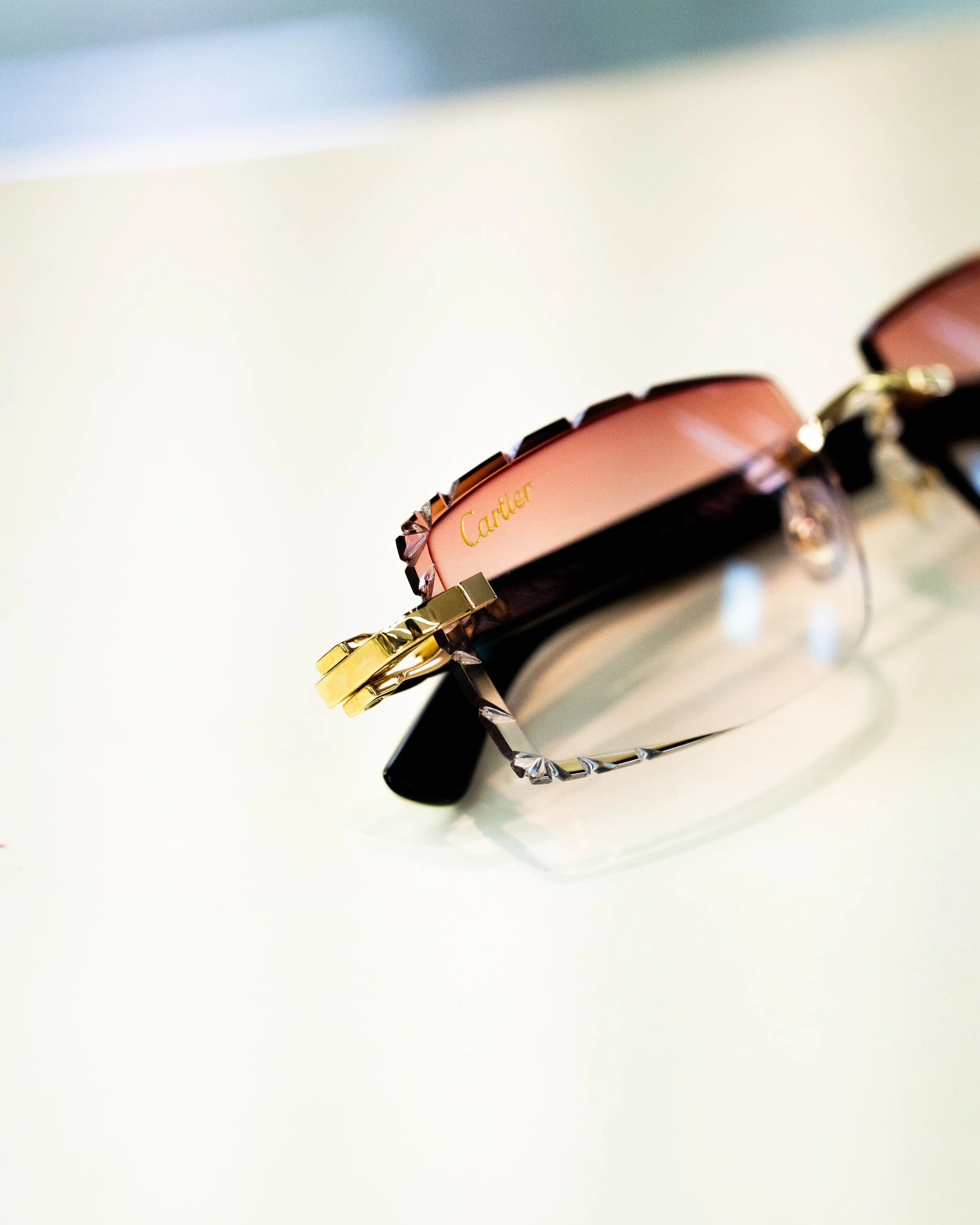 Close-up of a Cartier bracelet with gold and black accents on a white surface.