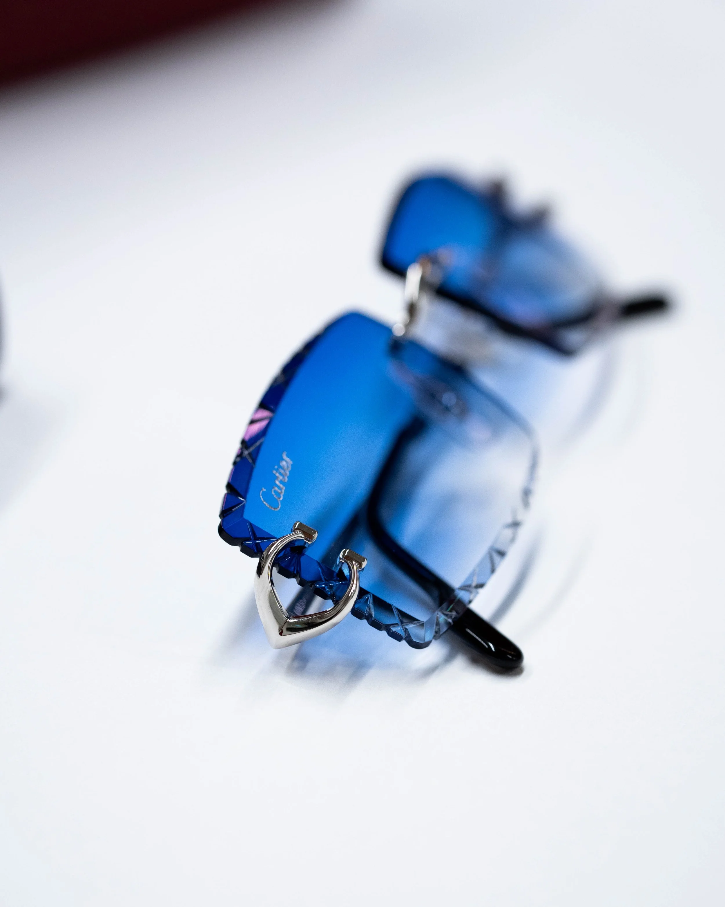 Close-up of a keychain with a car key fob attached, featuring a blue design and a silver ring, resting on a white surface.