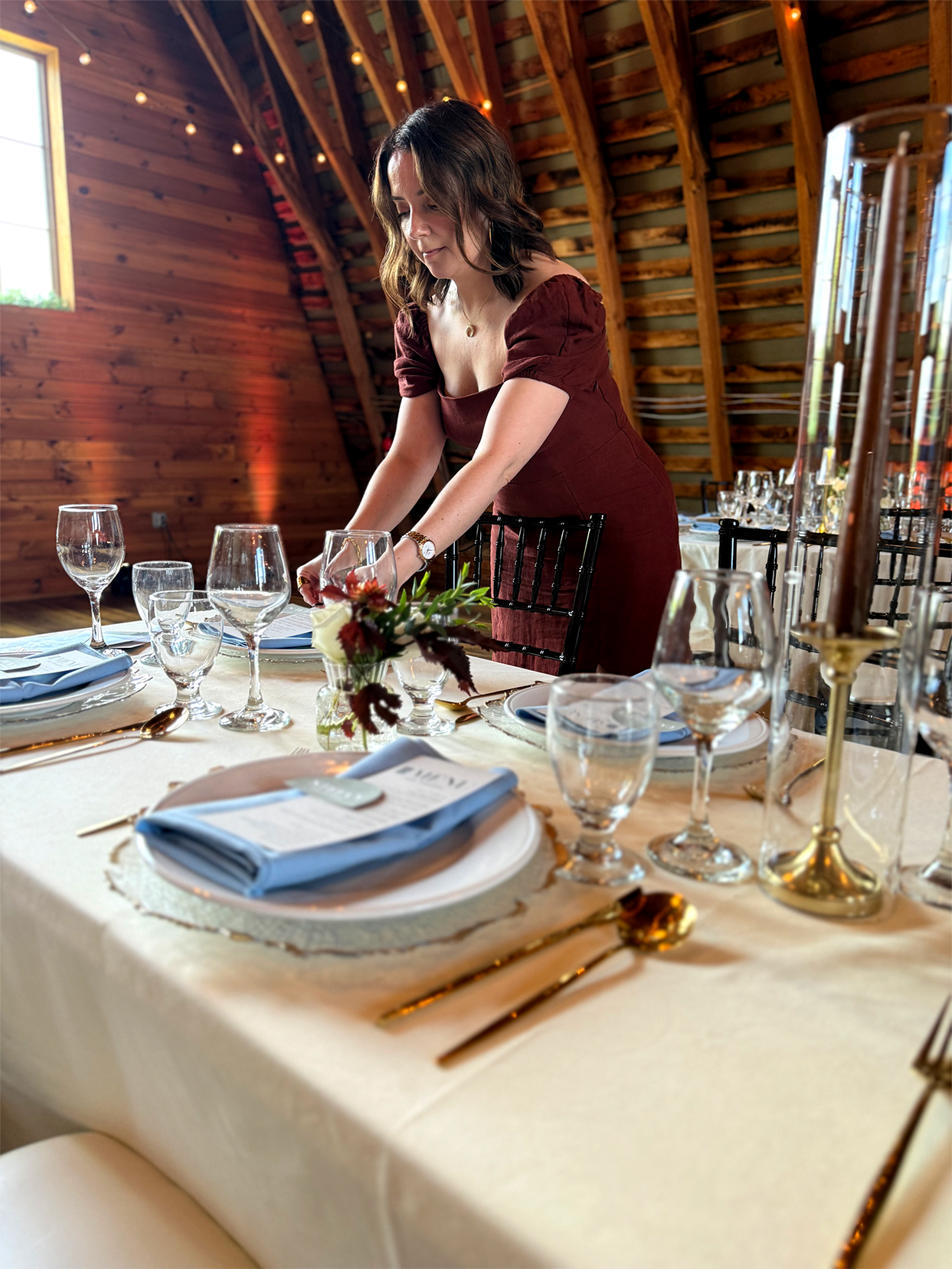 Studio Amper designer Svetlana styling wedding stationery and place-setting details at a reception table.