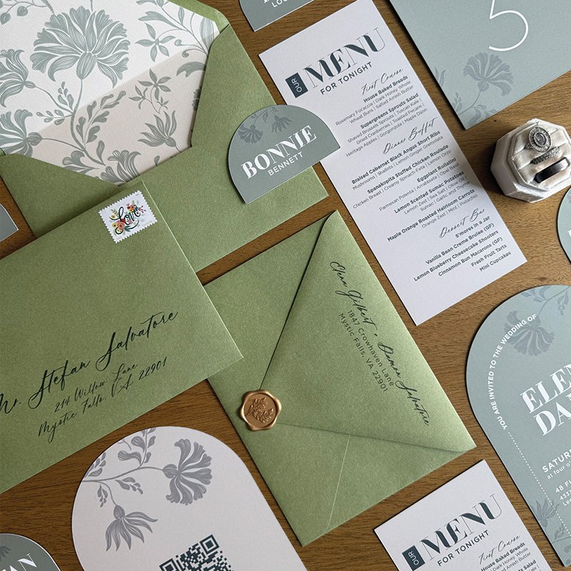 Green wedding invitation suite with botanical envelope liner and coordinating wedding menus for a cohesive celebration.
