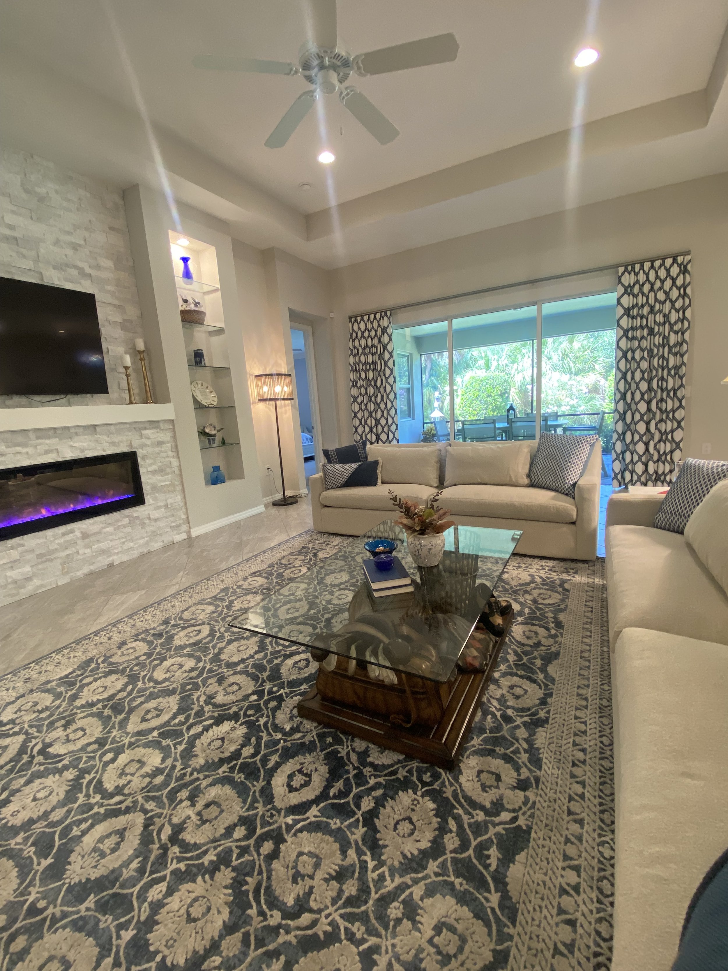 Occupied staged living room. Navy blue, white and neutrals bring out the best in this home along with just the right accessories and details.