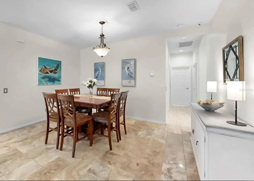 Occupied and staged Dining Room with beautiful accessories that add to the ambiance. Accent lighting and beautiful magnolia flower arrangement adds warmth and elegance.