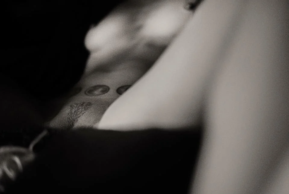 A close-up black and white photo of a person holding an object, with some buttons or symbols visible on the object.