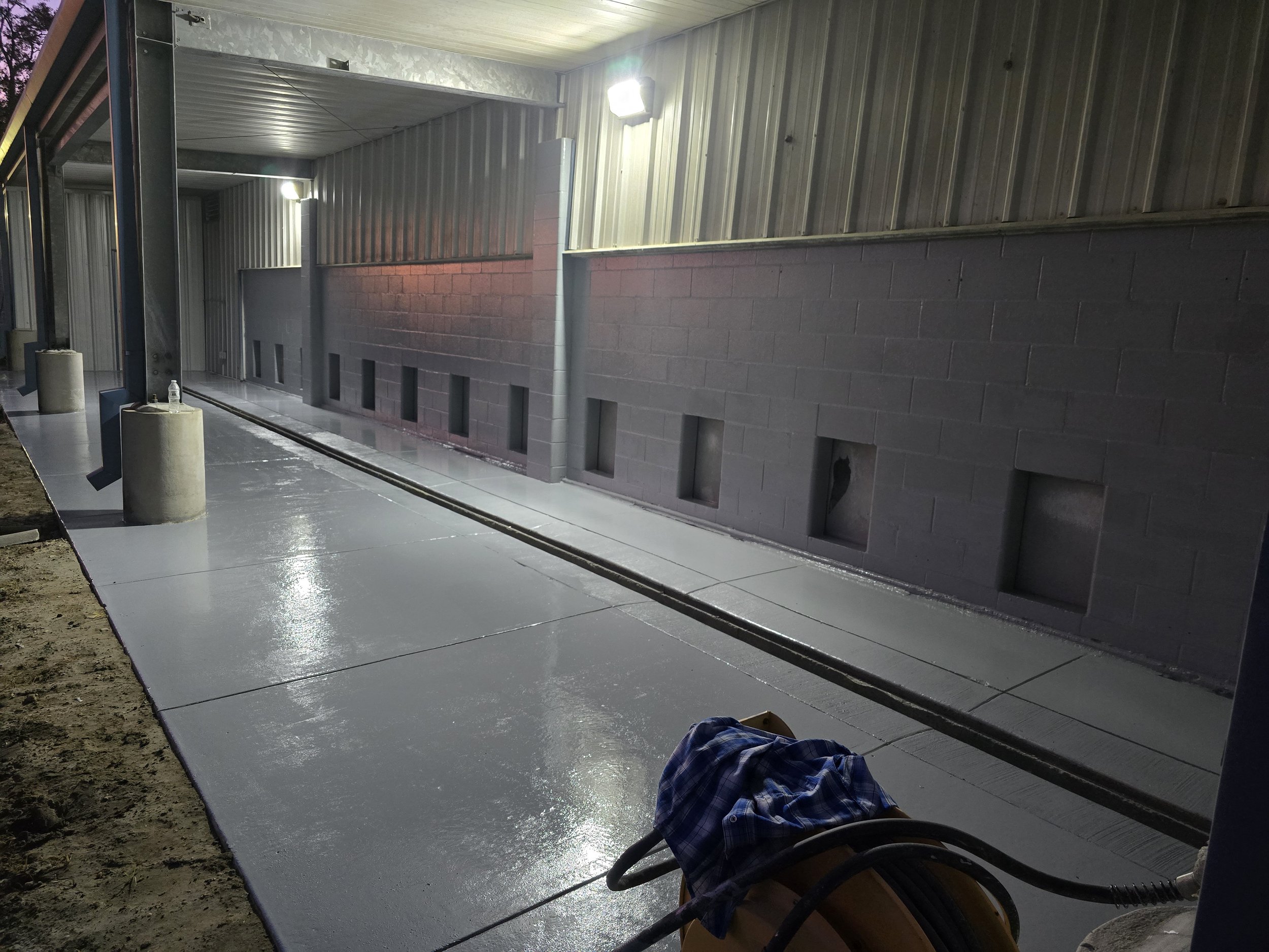 Waterproofing epoxy coating installed on an exterior concrete walkway by The Brothers Shine.