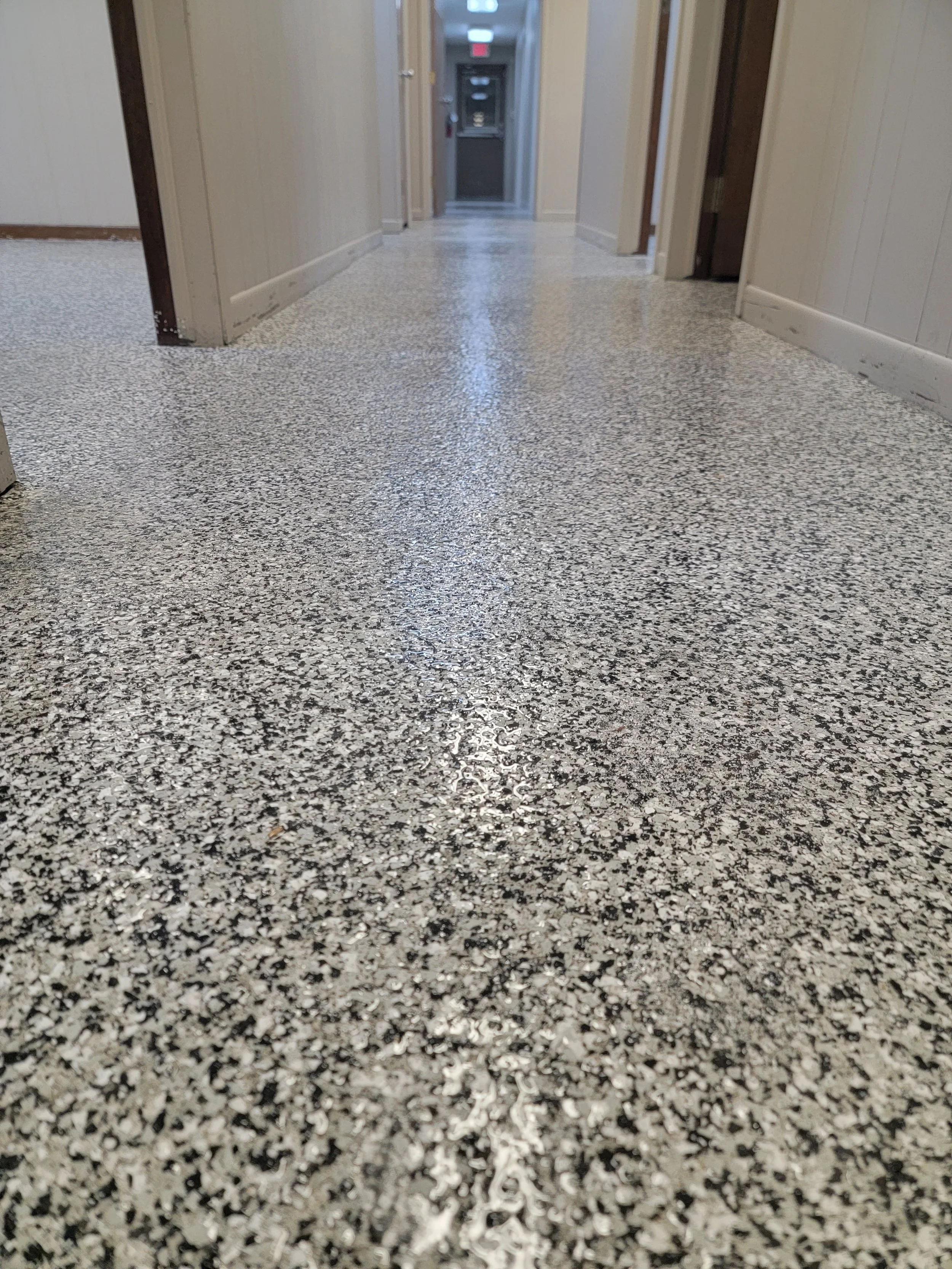 Finished epoxy flake flooring in a commercial hallway installed by The Brothers Shine