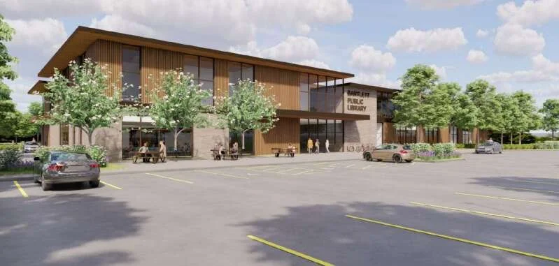 Modern public library building with parking lot and trees