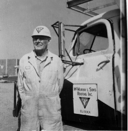 Thomas J. McMurray beside a McMurray & Sons Roofing truck