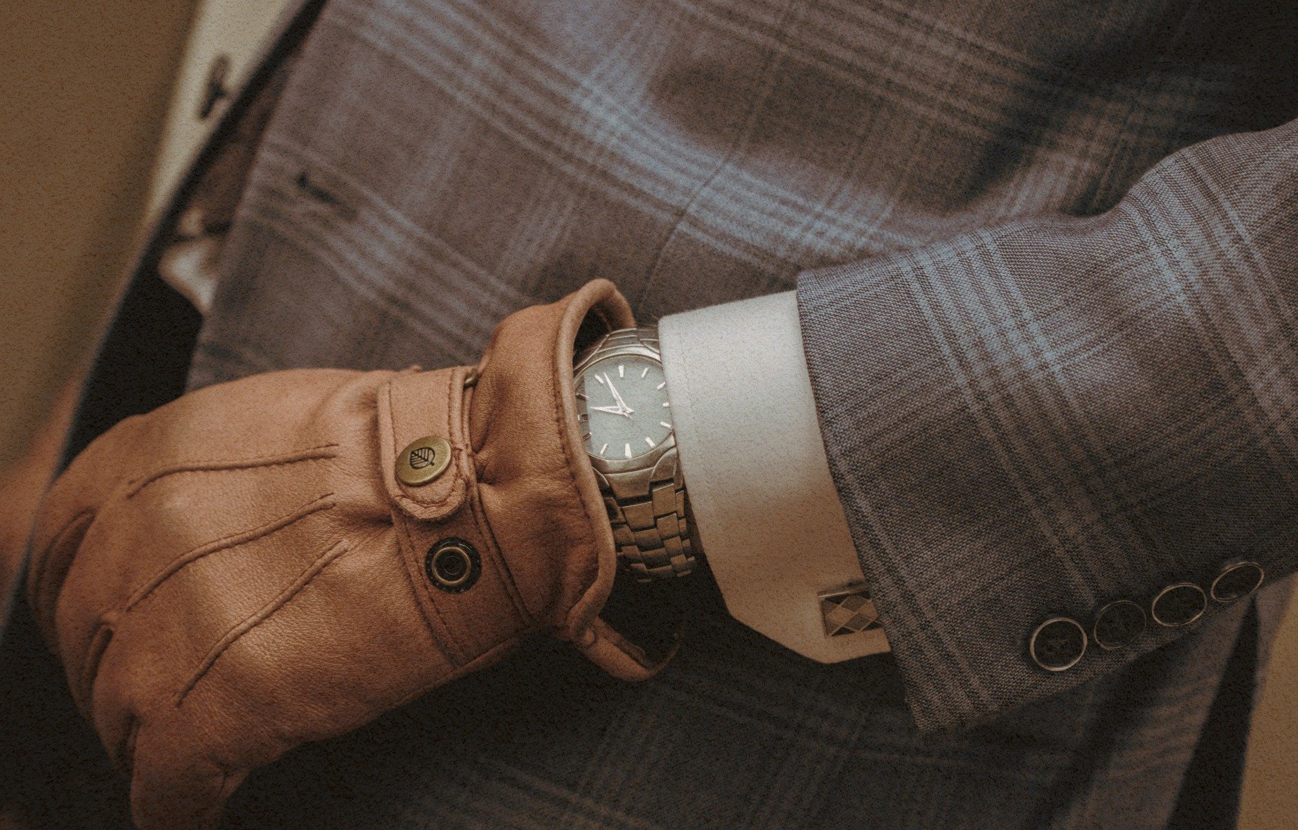 A person wearing a gray plaid suit as part of the roofing company McMurray & Sons branding images.