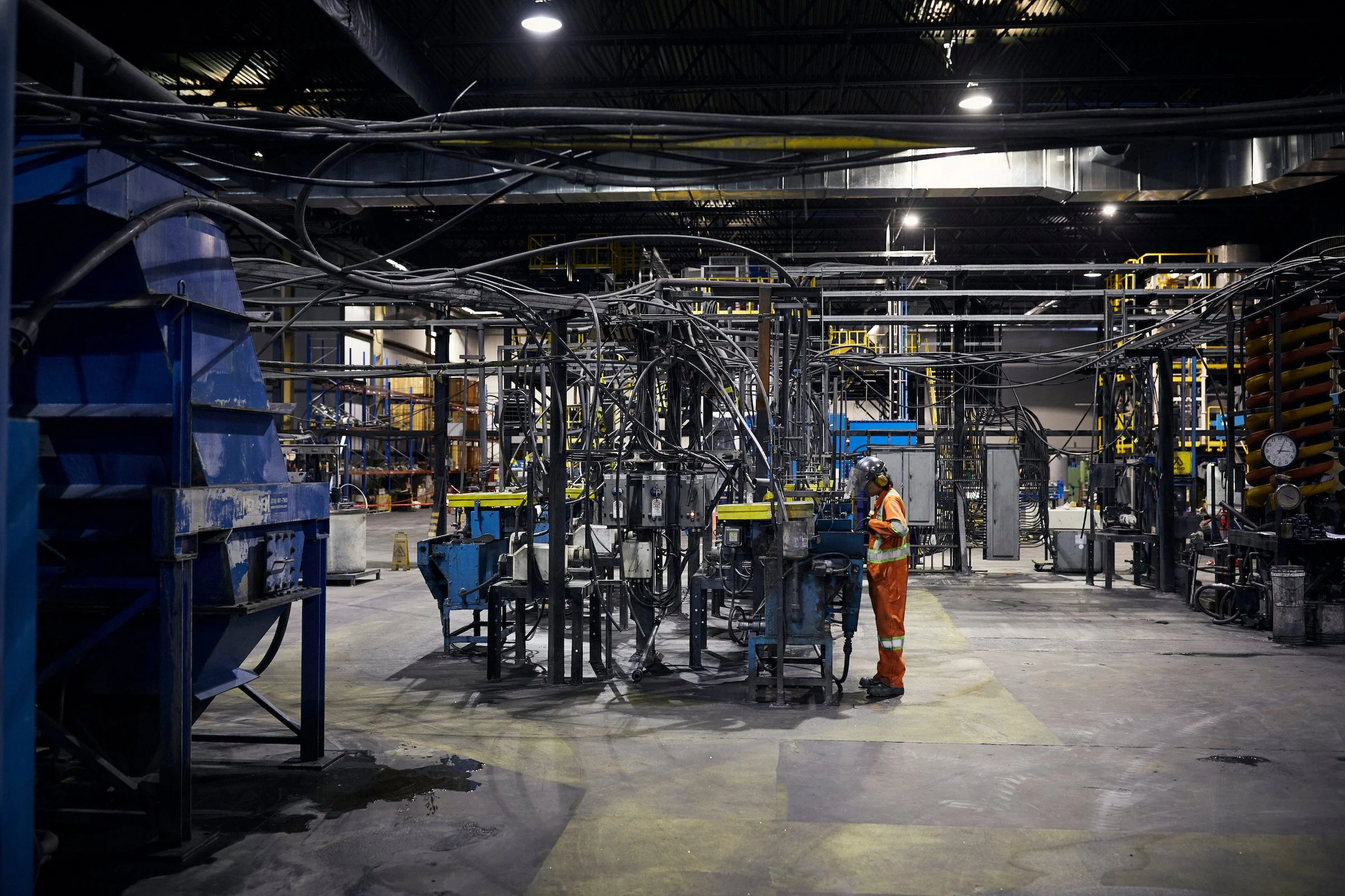 A worker in orange coveralls at the processing plant, Nouveau Monde Graphite, Saint-Michel-des-Saints, Quebec.