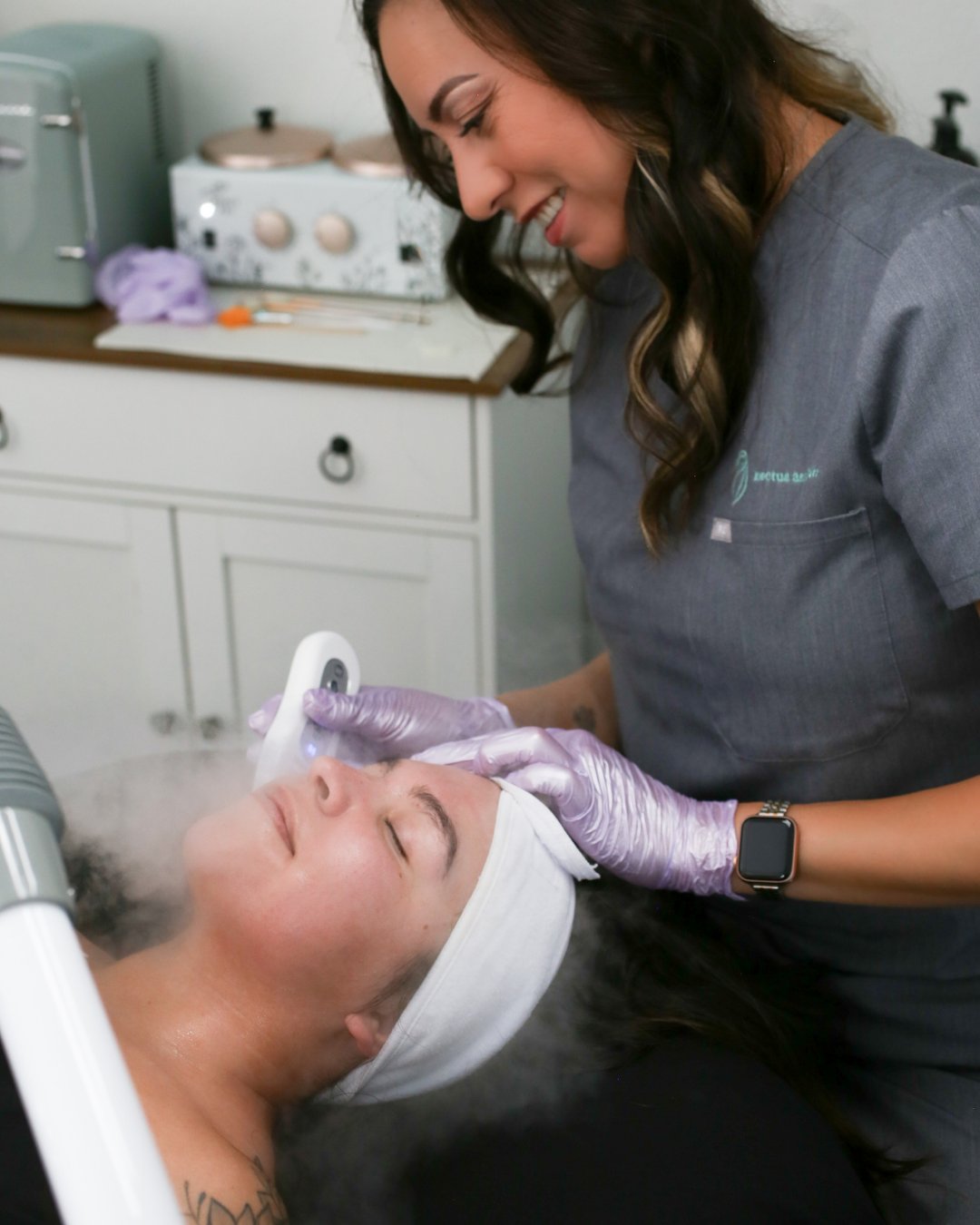 A woman is receiving a facial treatment from an esthetician in a spa in Henderson Nevada