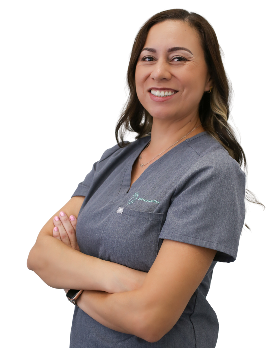 A smiling skincare specialist in henderson nv with brown hair wearing gray scrubs with a logo on the chest, standing with arms crossed after giving the best facial in henderson.