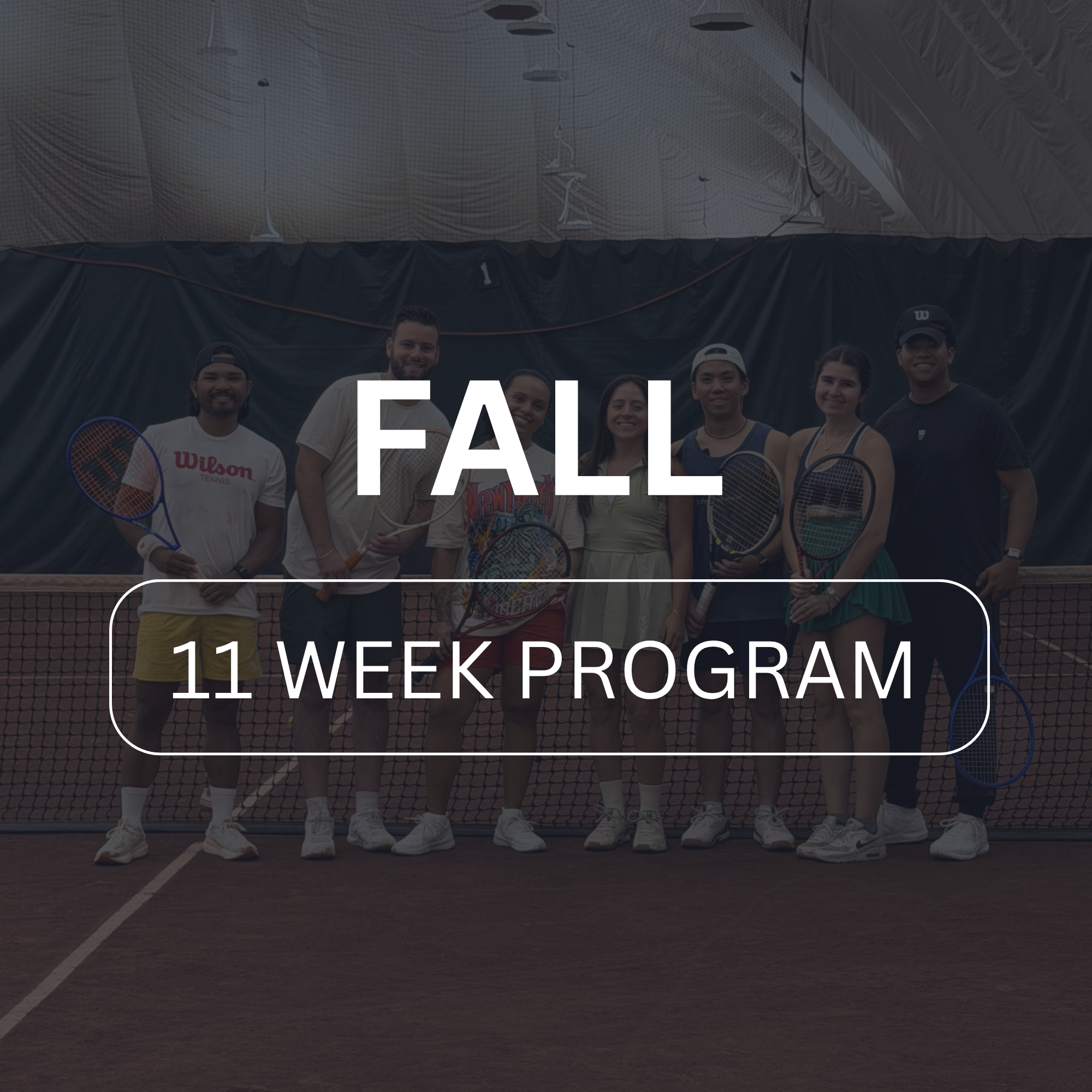 Group of seven people standing on a tennis court, holding tennis rackets, smiling for a group photo, with a black curtain and tennis net behind them, and a large sign that reads 'FALLL 11 WEEK PROGRAM' in the foreground.