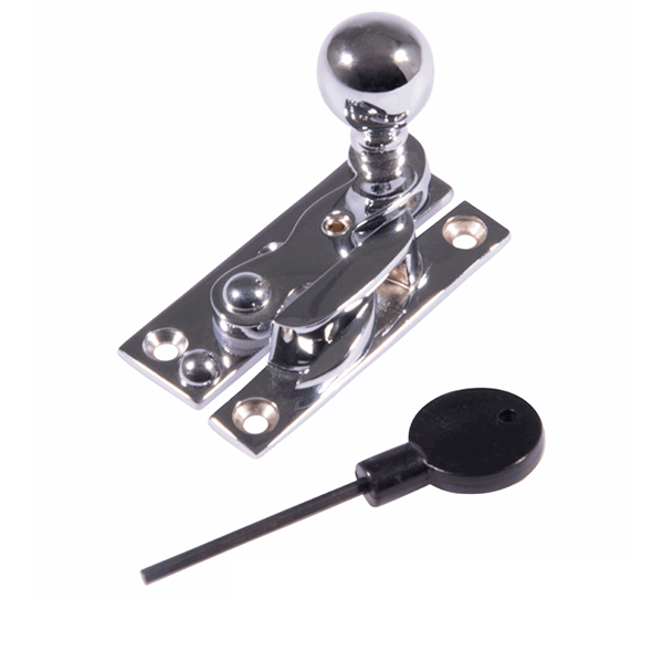 A metal latch with a spherical handle and a black lock key with a long thin shaft.