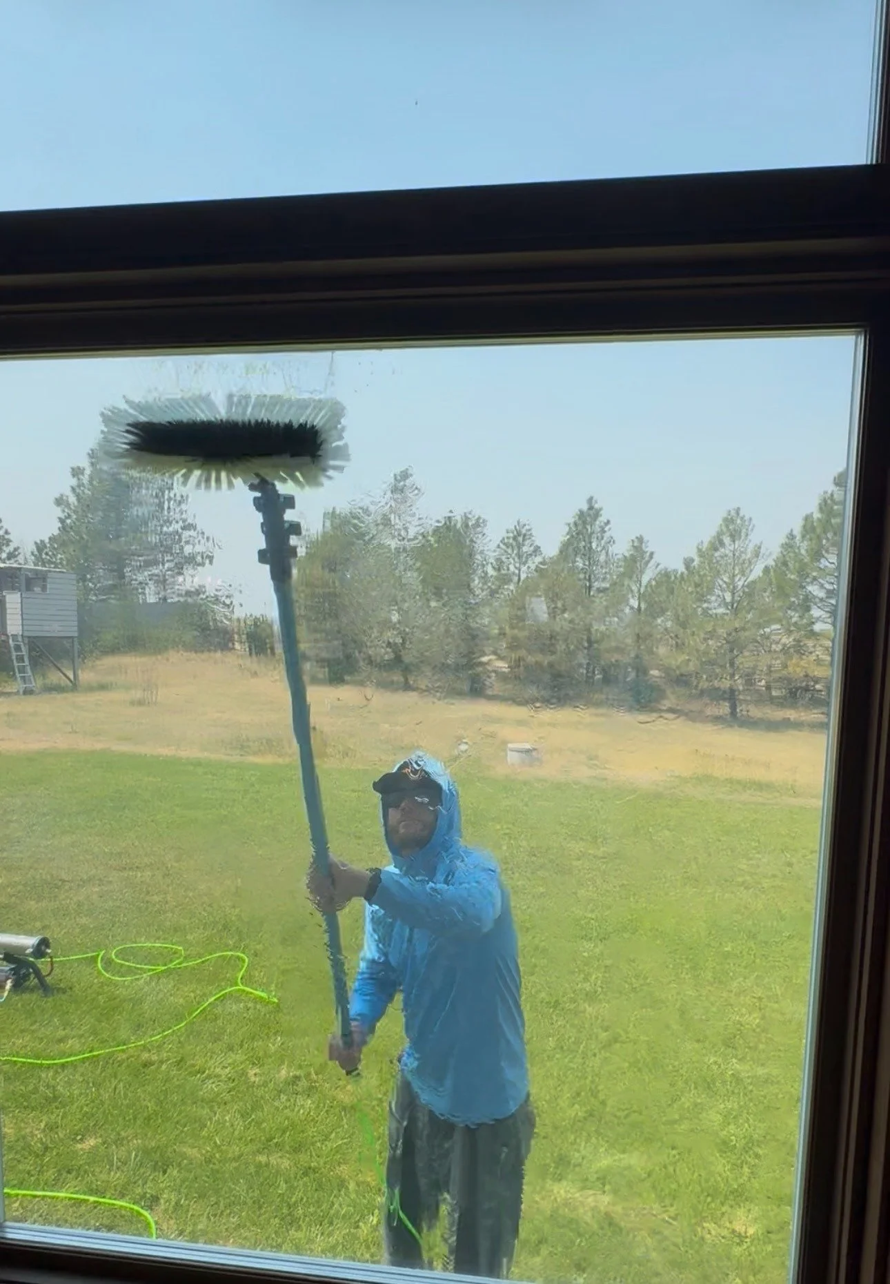 Window cleaning technician working in rainy weather conditions Cheyenne, WY