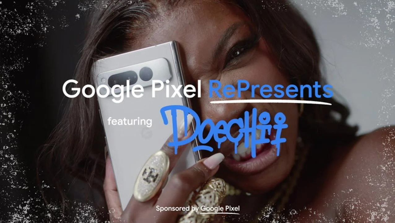 A woman holding a Google Pixel smartphone close to her face, partially covering her eye and smiling. She is wearing jewelry, including rings and a necklace.