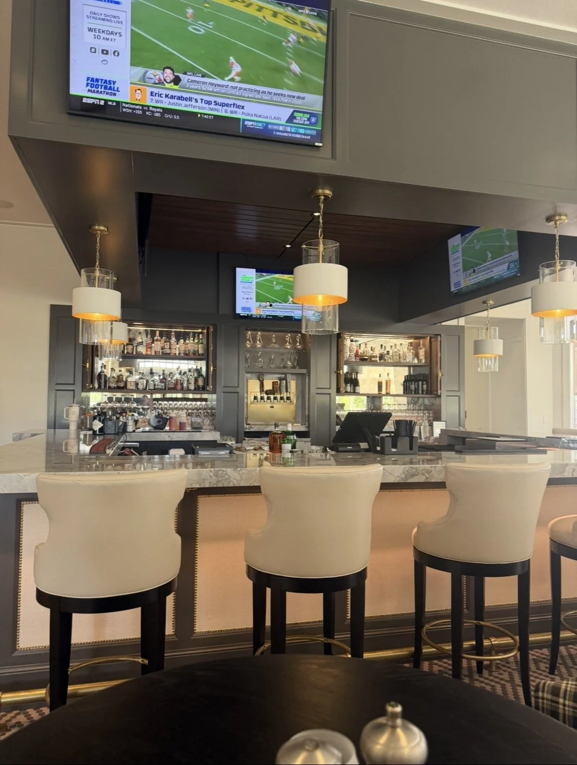 Hallbrook Country Club bar in Leawood, Kansas, with televisions and marble bar seating