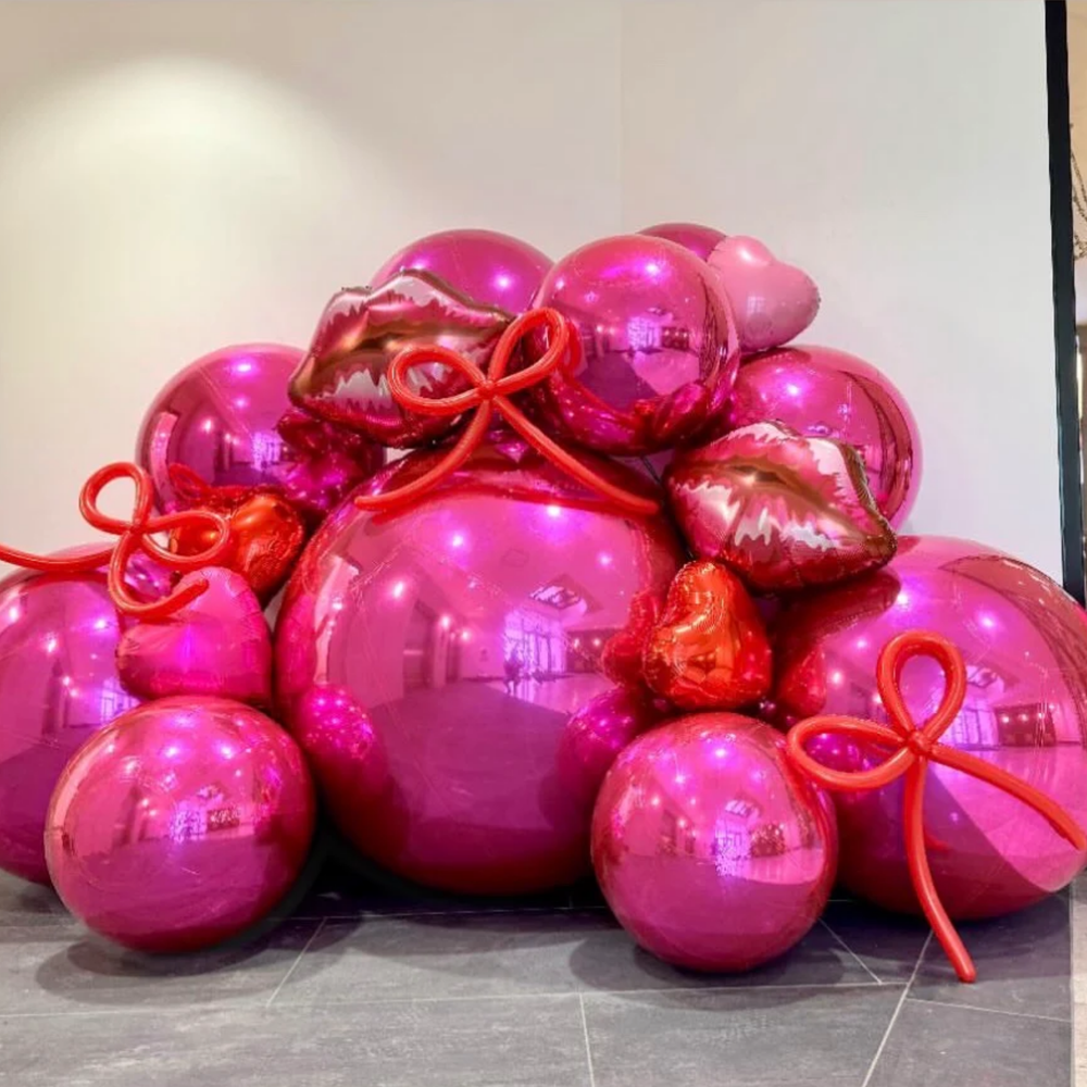 Sculptural pink metallic globes and playful pink ribbon balloons